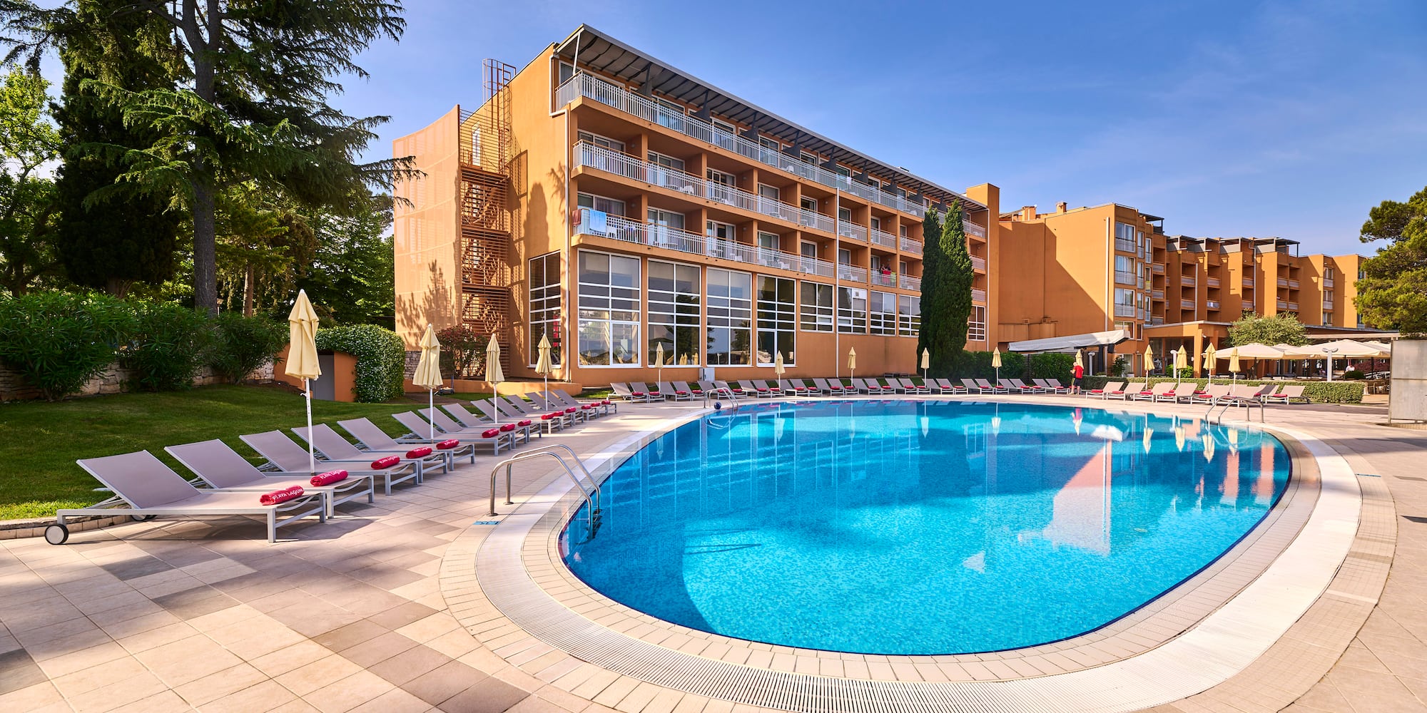 a pool with lounge chairs and a building