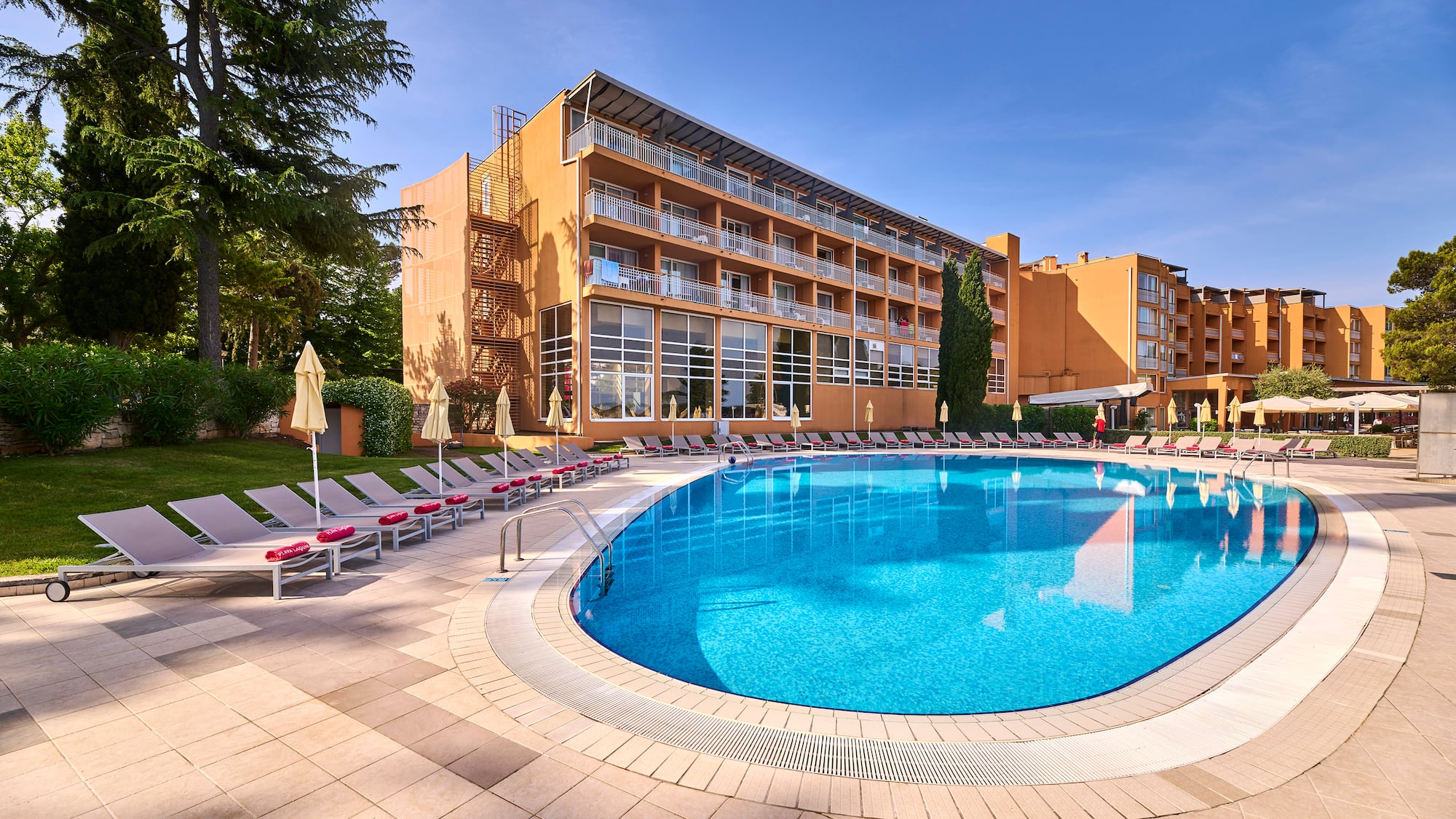 a pool with lounge chairs and a building