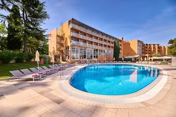 a pool with lounge chairs and a building