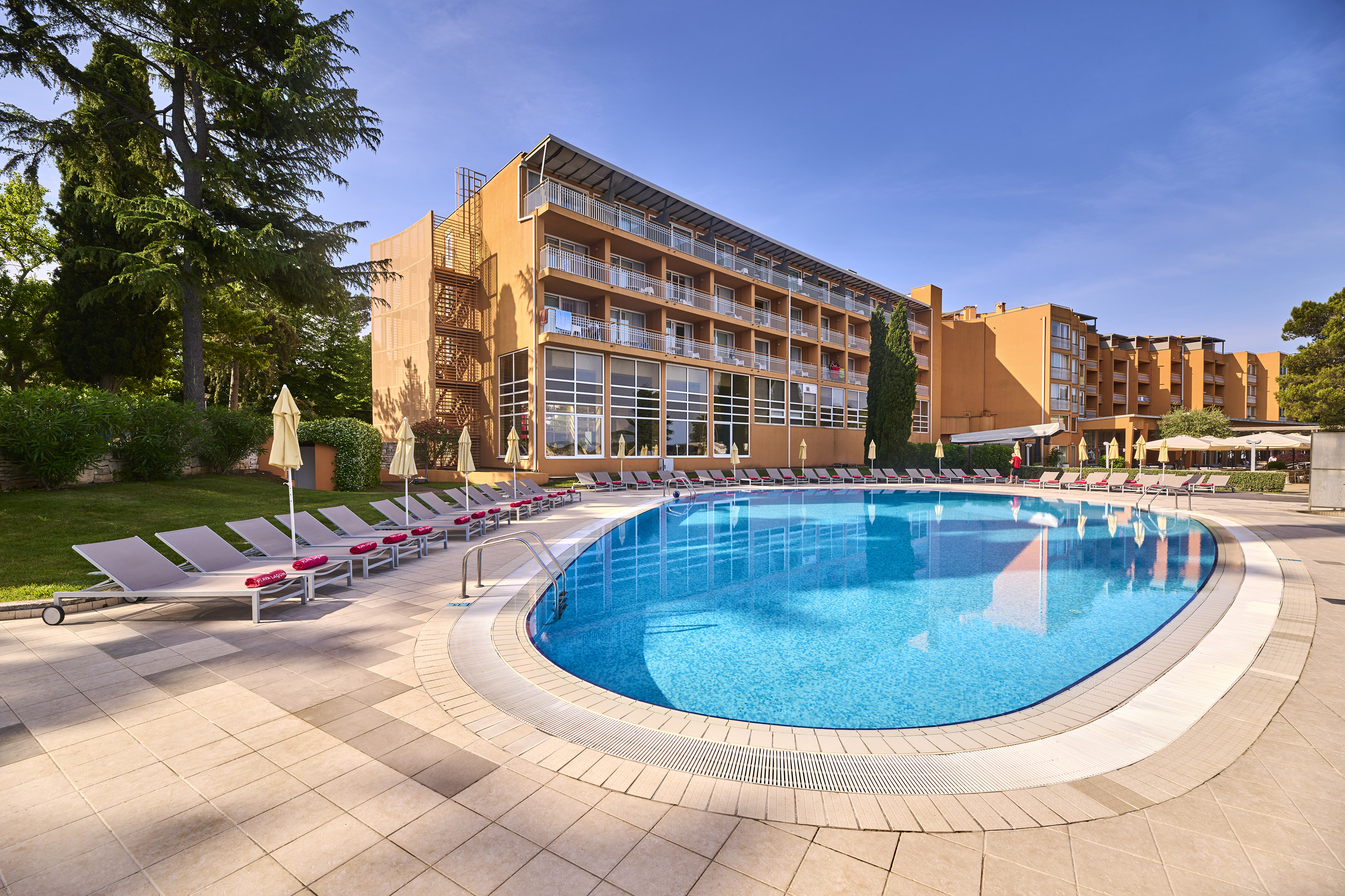 a pool with lounge chairs and a building