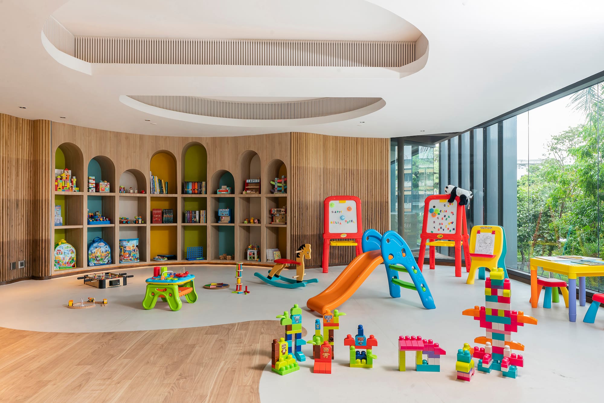 Colorful children's playroom with slide, blocks, shelves, and modern design.
