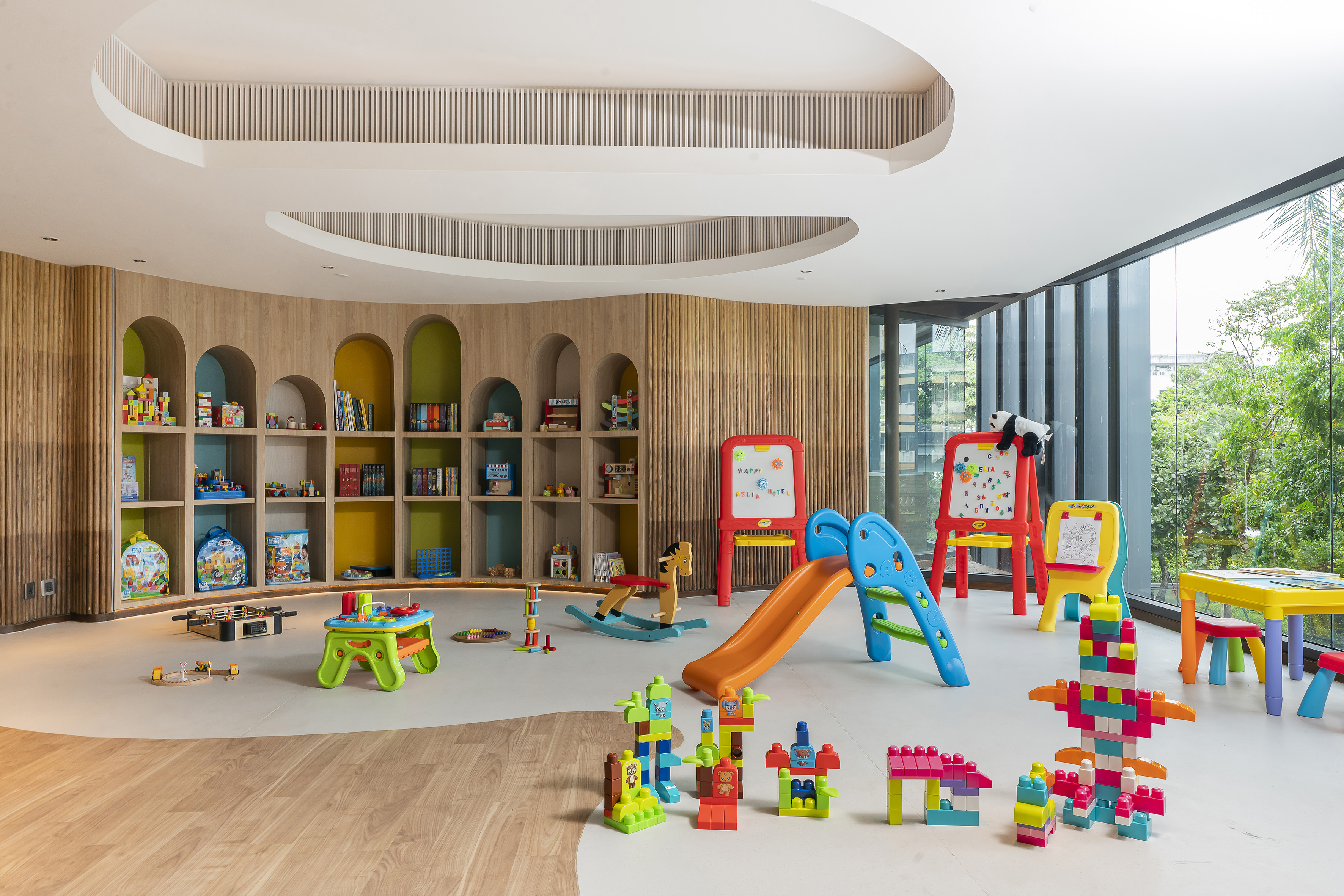 Colorful children's playroom with slide, blocks, shelves, and modern design.