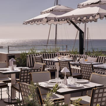 a table and chairs on a patio overlooking the ocean