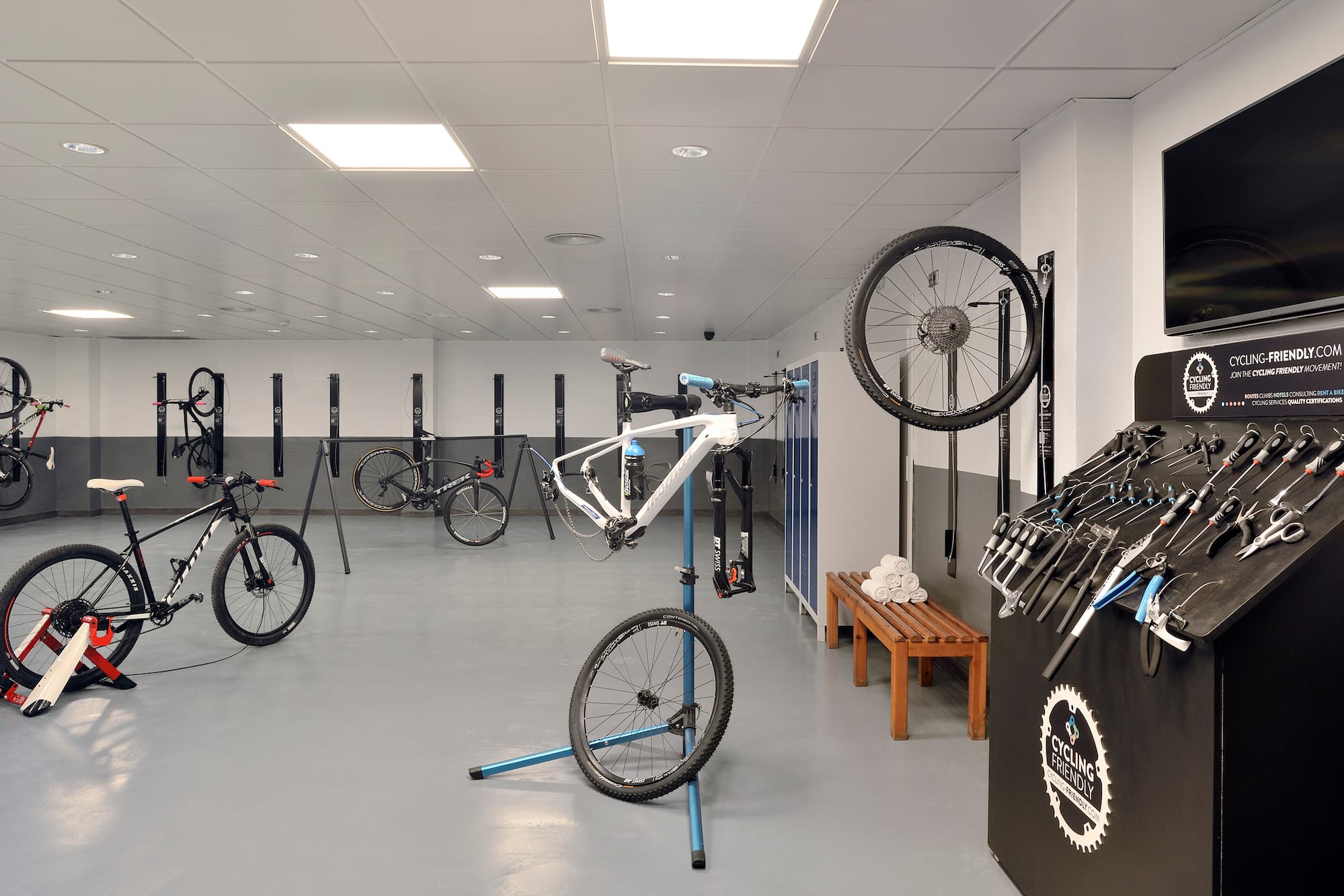 Cycling-friendly bike service room with repair tools, stands, and bike storage.