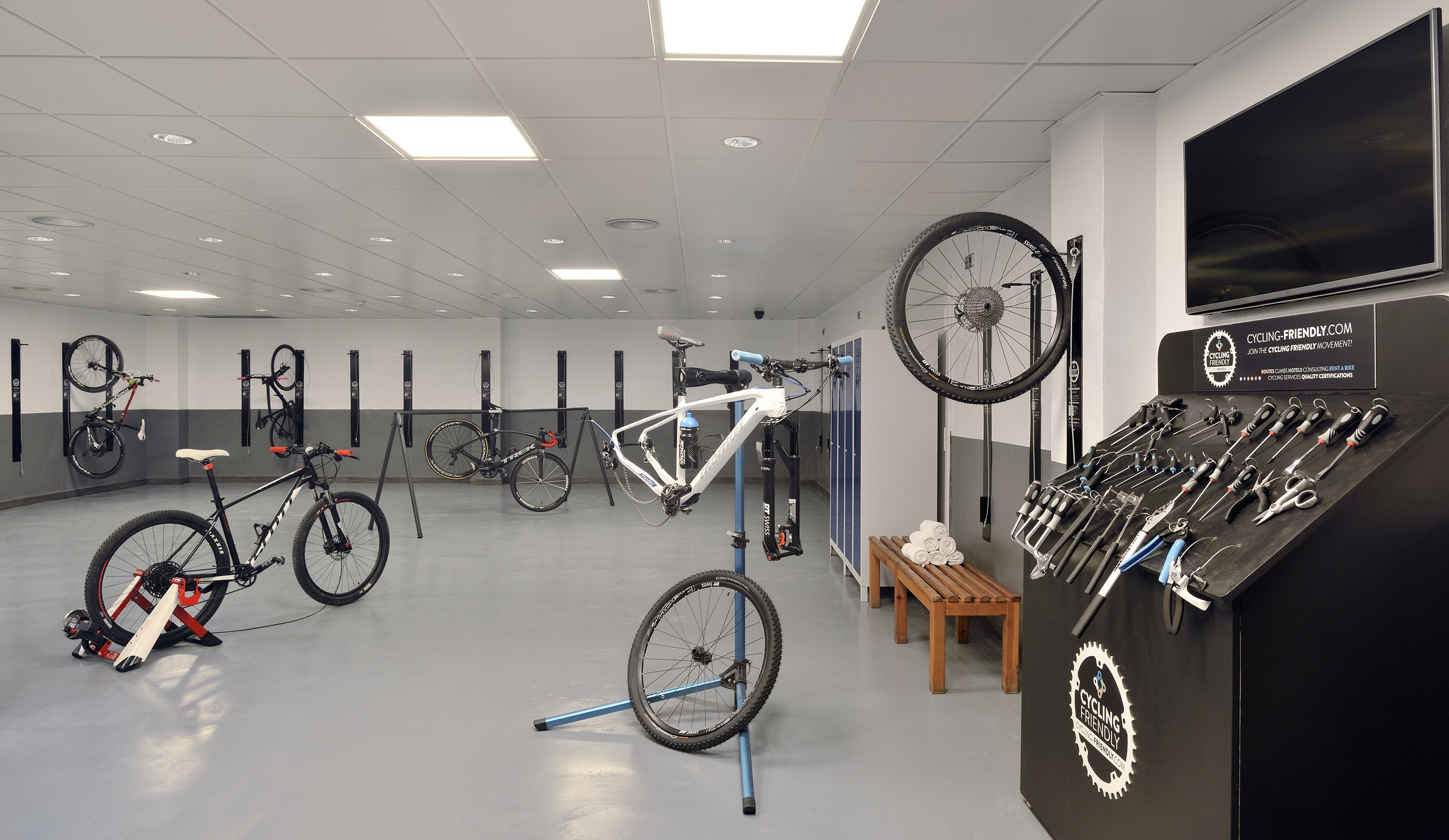 Cycling-friendly bike service room with repair tools, stands, and bike storage.