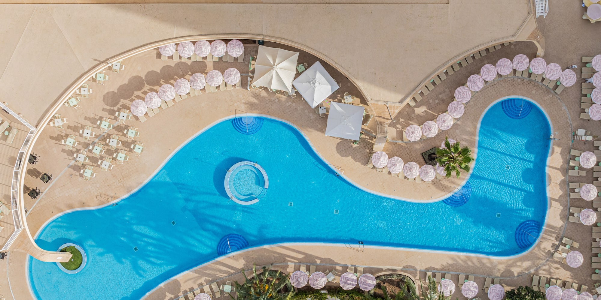 a swimming pool with umbrellas and chairs