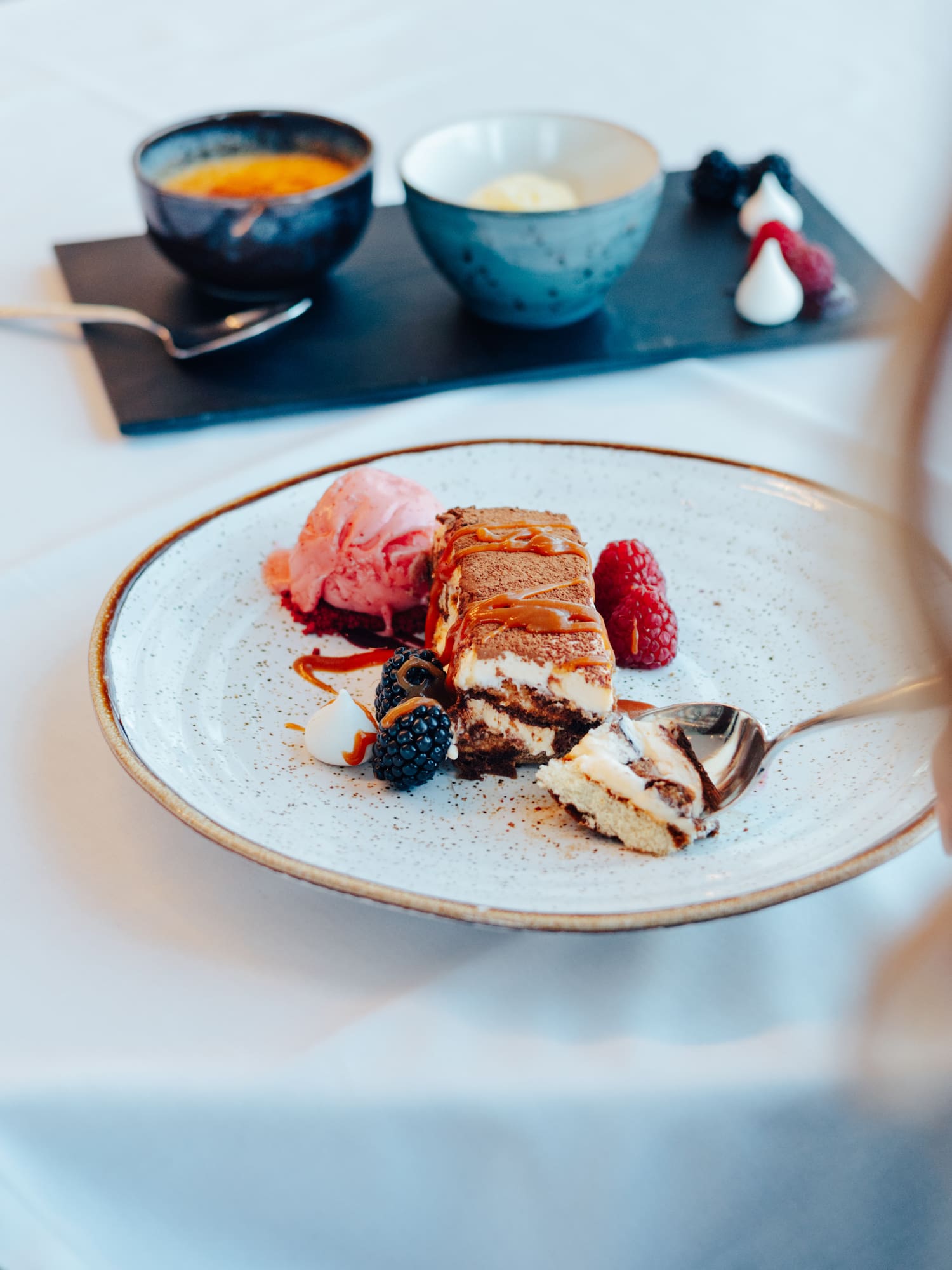 Restaurant dessert: Tiramisu with strawberry ice cream, fresh berries, caramel.