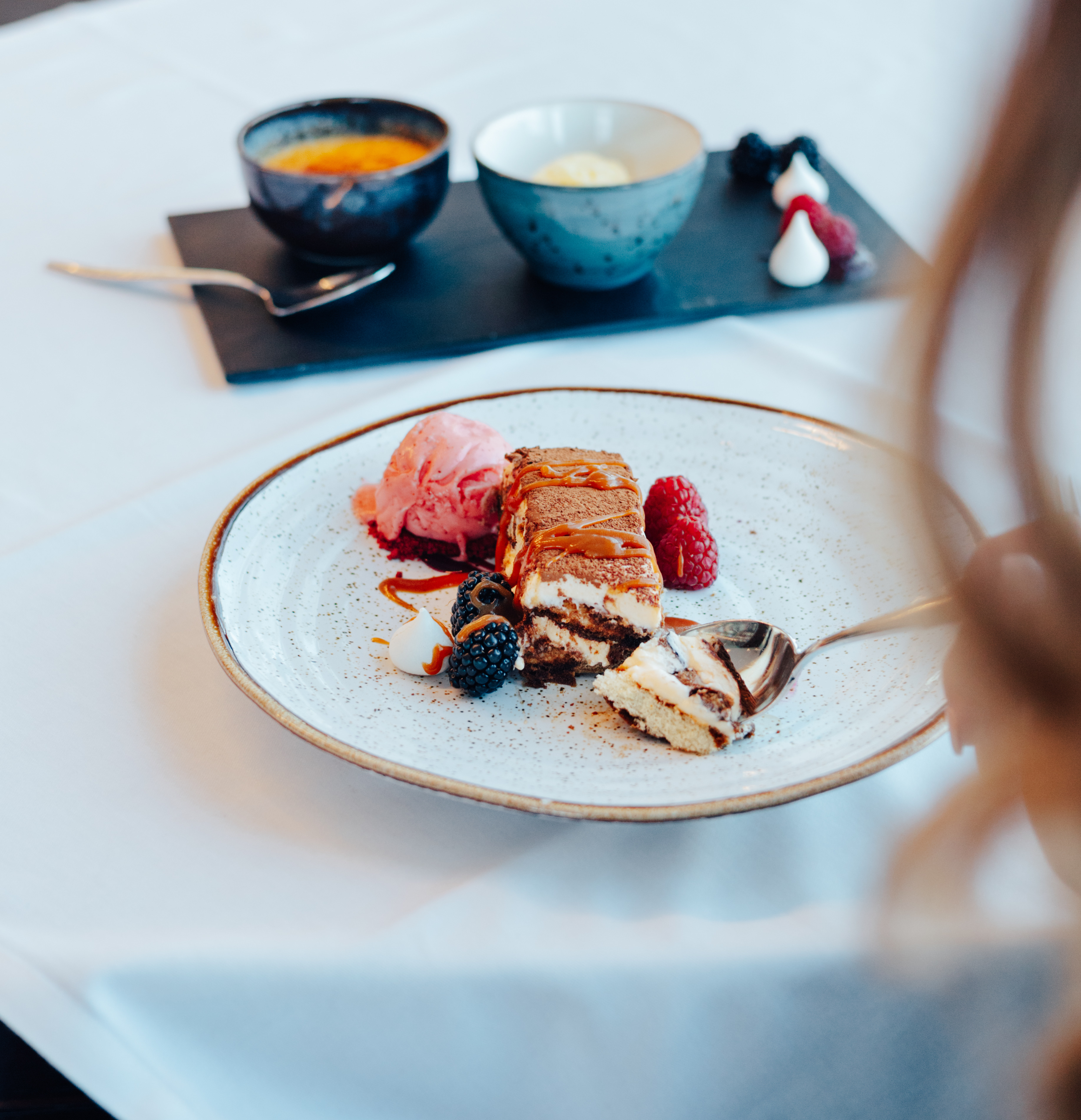 Restaurant dessert: Tiramisu with strawberry ice cream, fresh berries, caramel.