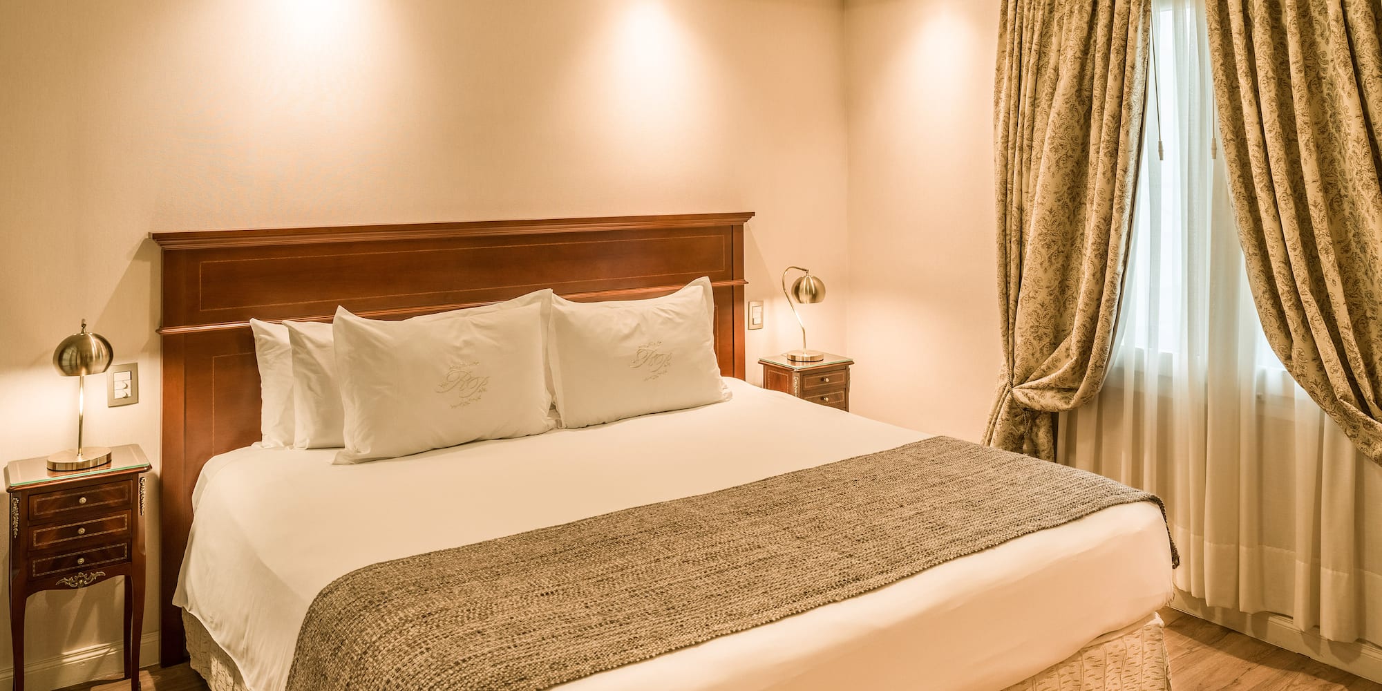 a bed with pillows and a lamp in a room