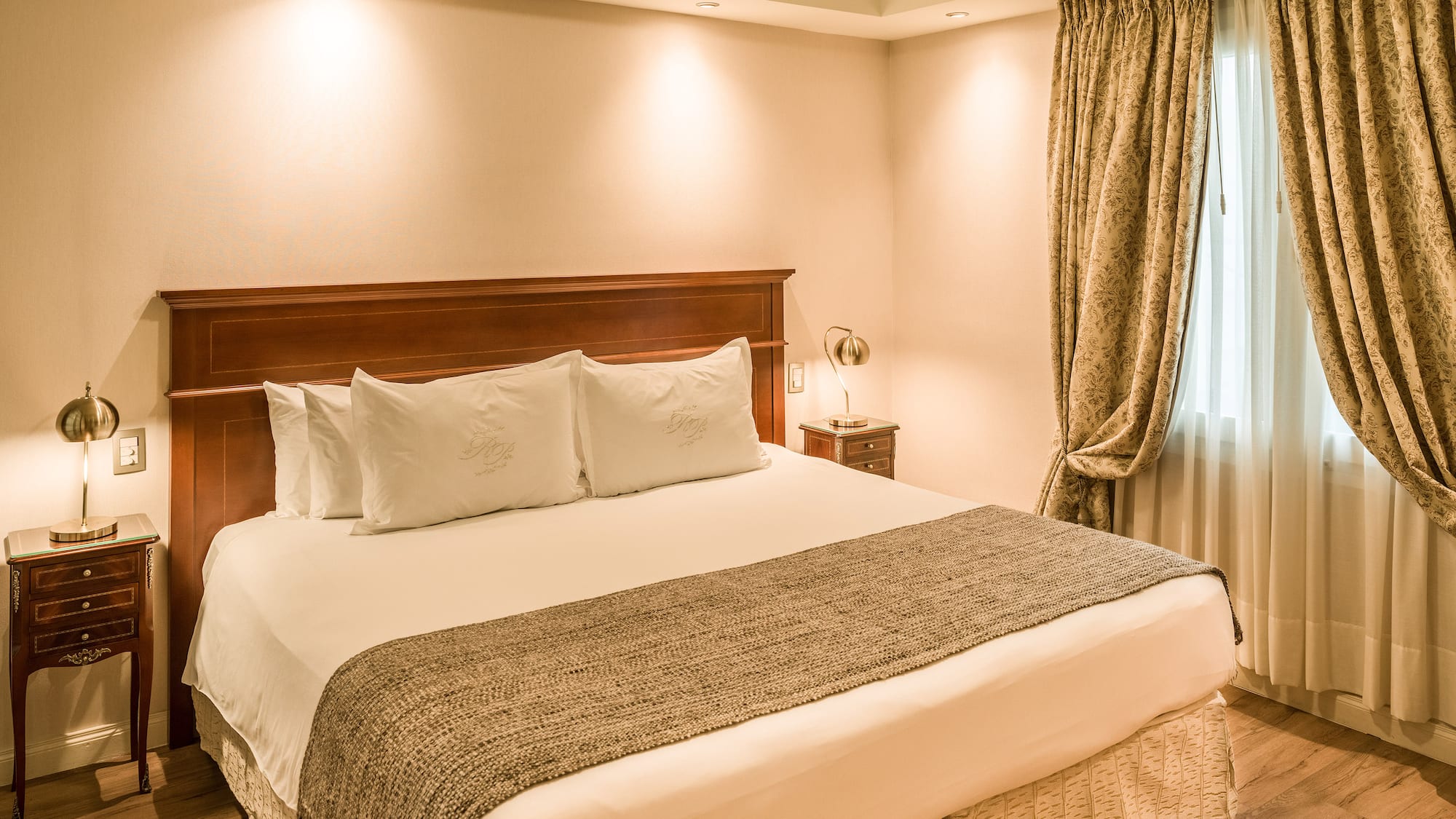 a bed with pillows and a lamp in a room