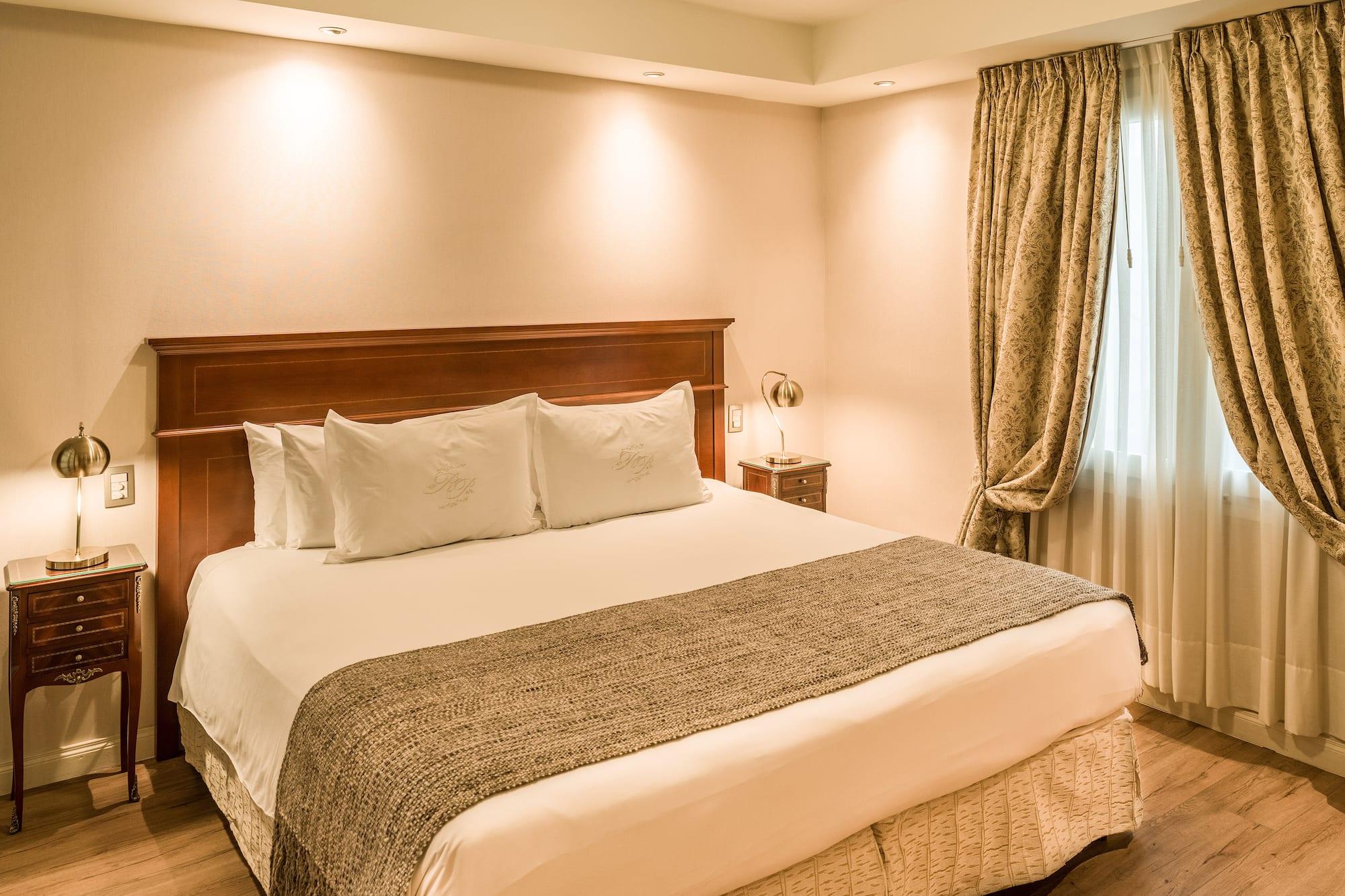 a bed with pillows and a lamp in a room