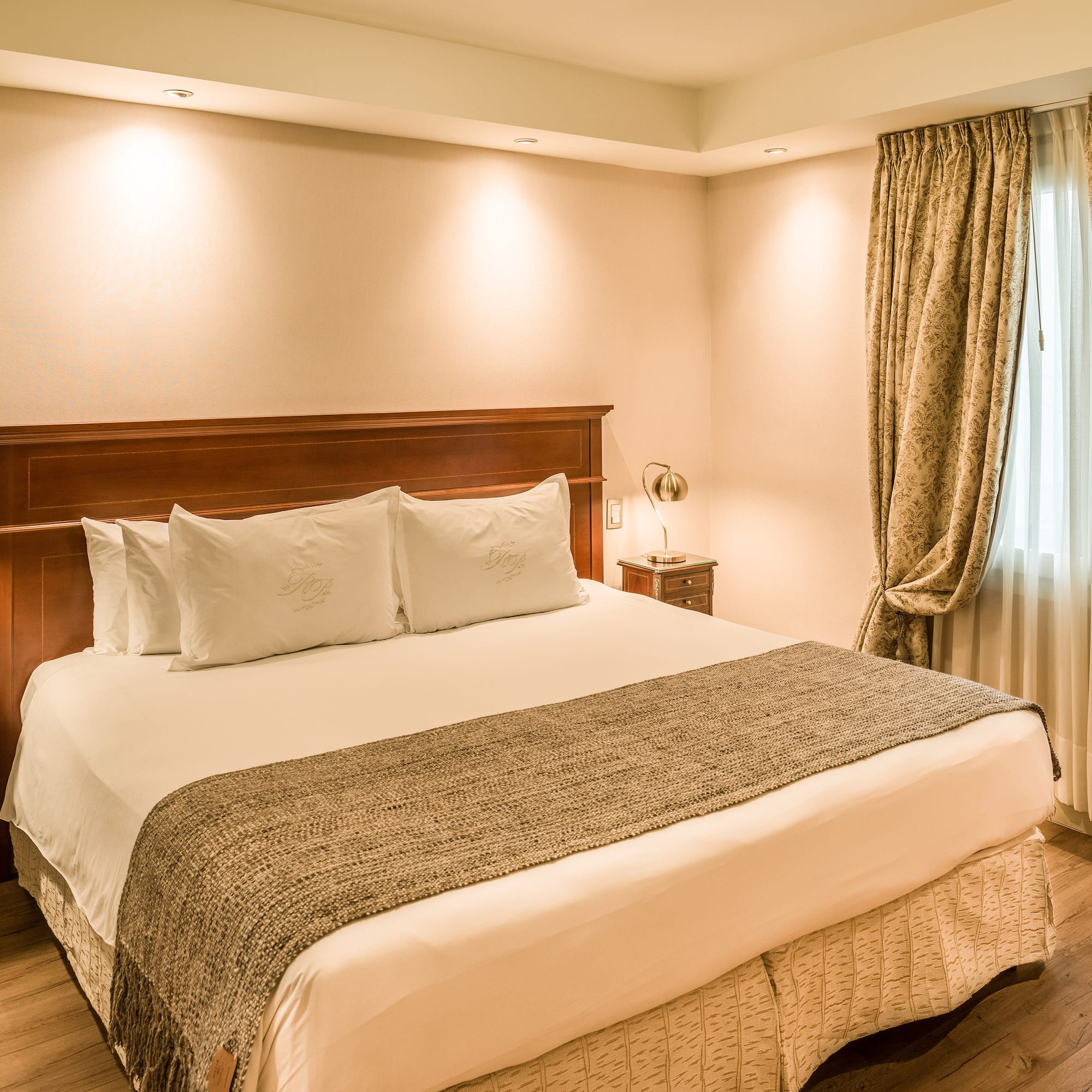 a bed with pillows and a lamp in a room