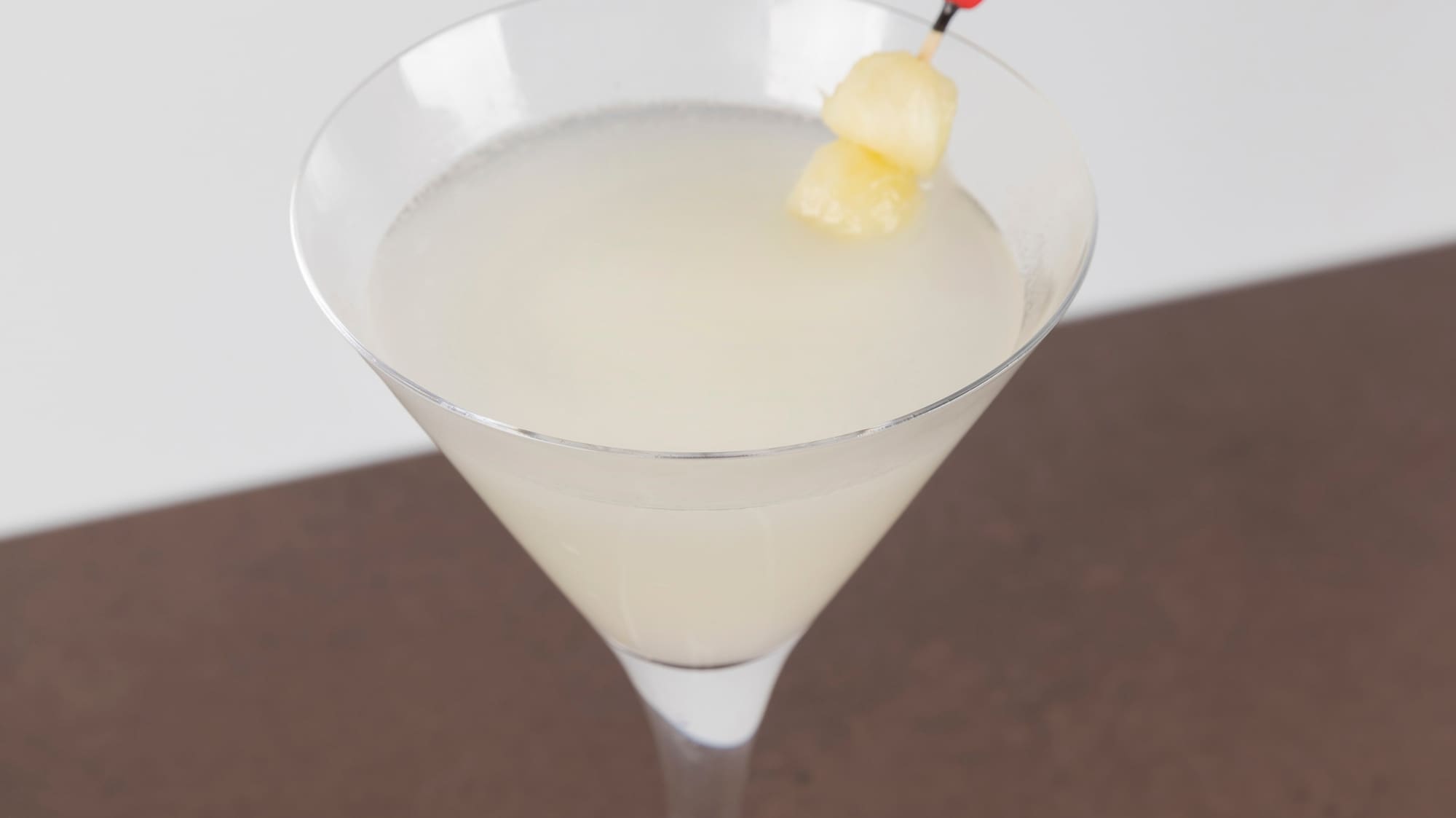 a glass with a drink and a stick on it