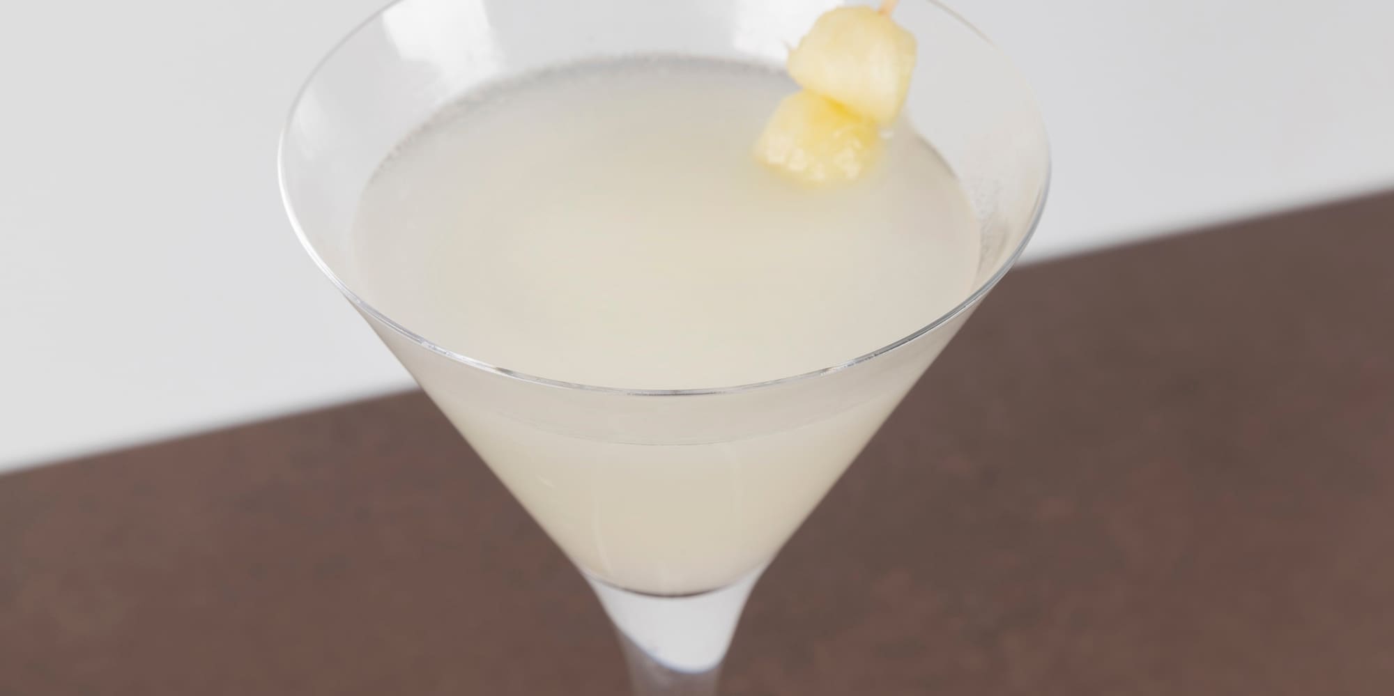 a glass with a drink and a stick on it