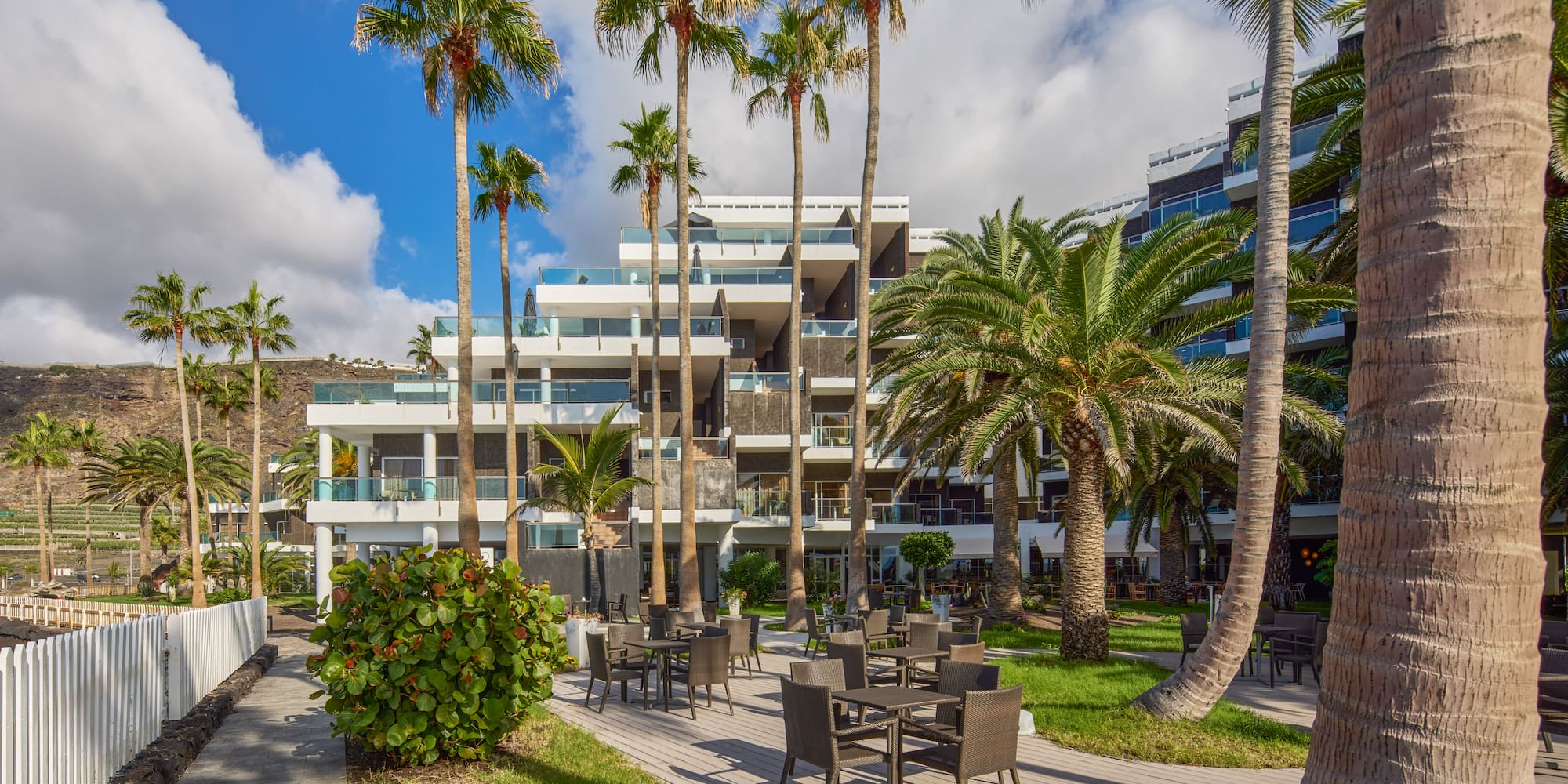 a hotel with palm trees and chairs