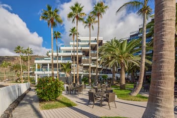 a hotel with palm trees and chairs