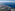 Aerial view of Mediterranean coastline, green land, coastal towns, and blue sea.