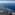 Aerial view of Mediterranean coastline, green land, coastal towns, and blue sea.