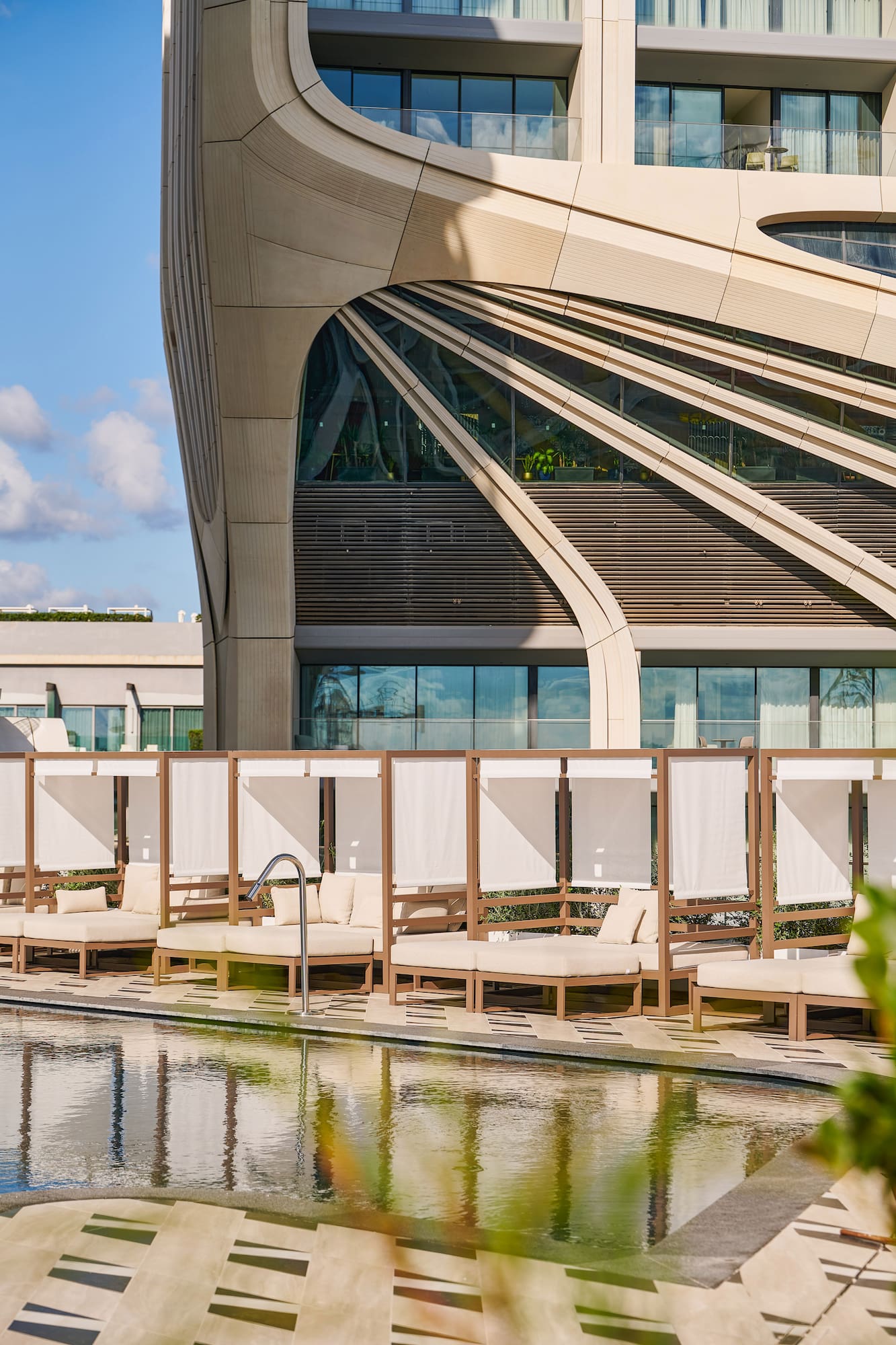 a pool with lounge chairs and a building with a pool