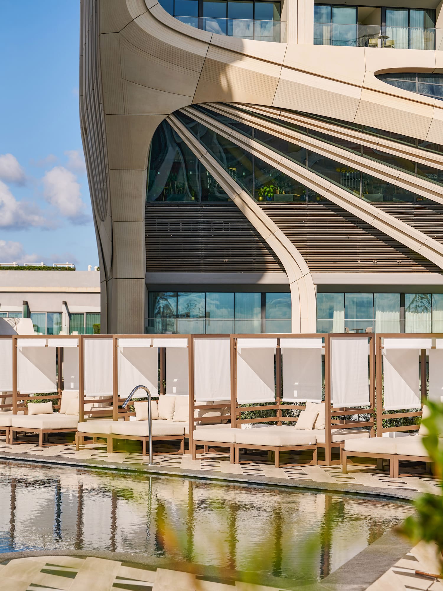 a pool with lounge chairs and a building with a pool