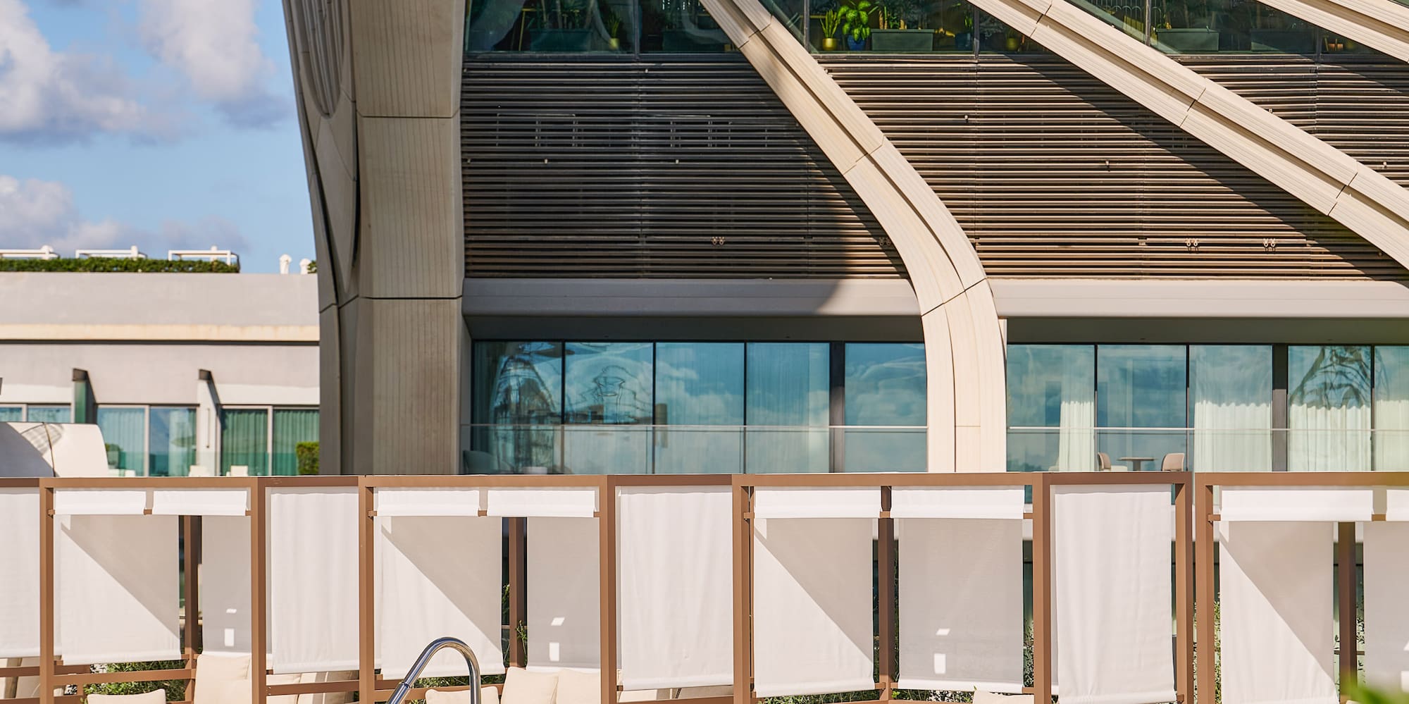 a pool with lounge chairs and a building with a pool