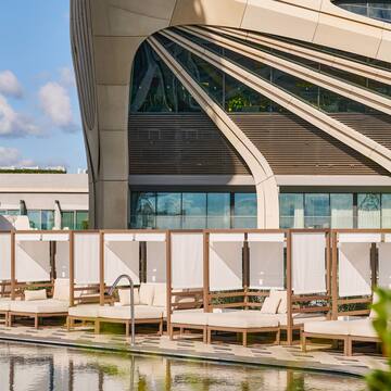 a pool with lounge chairs and a building with a pool