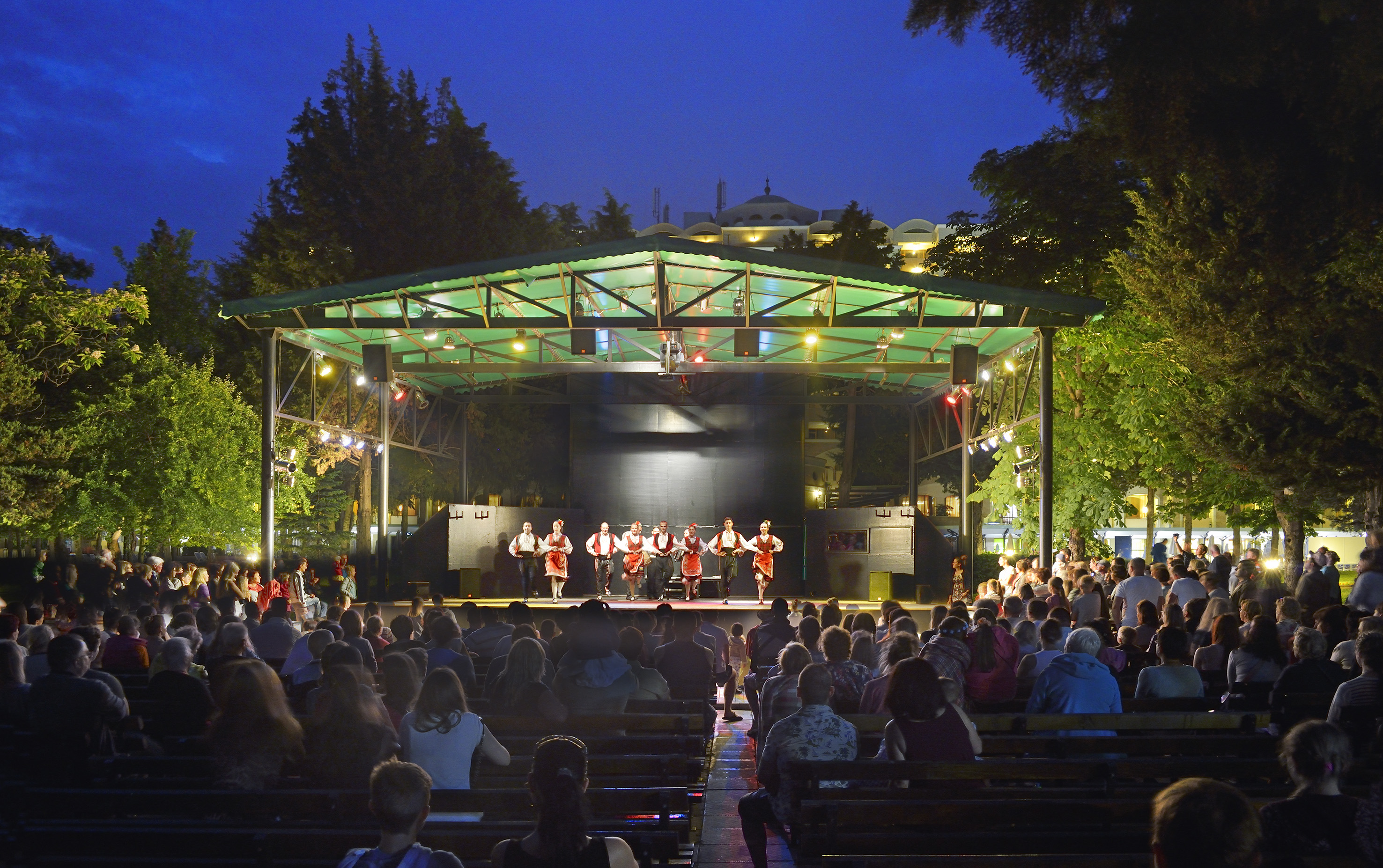 a group of people on a stage with Greek Theatre in the background