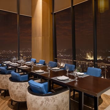 a long table with blue chairs and a city view