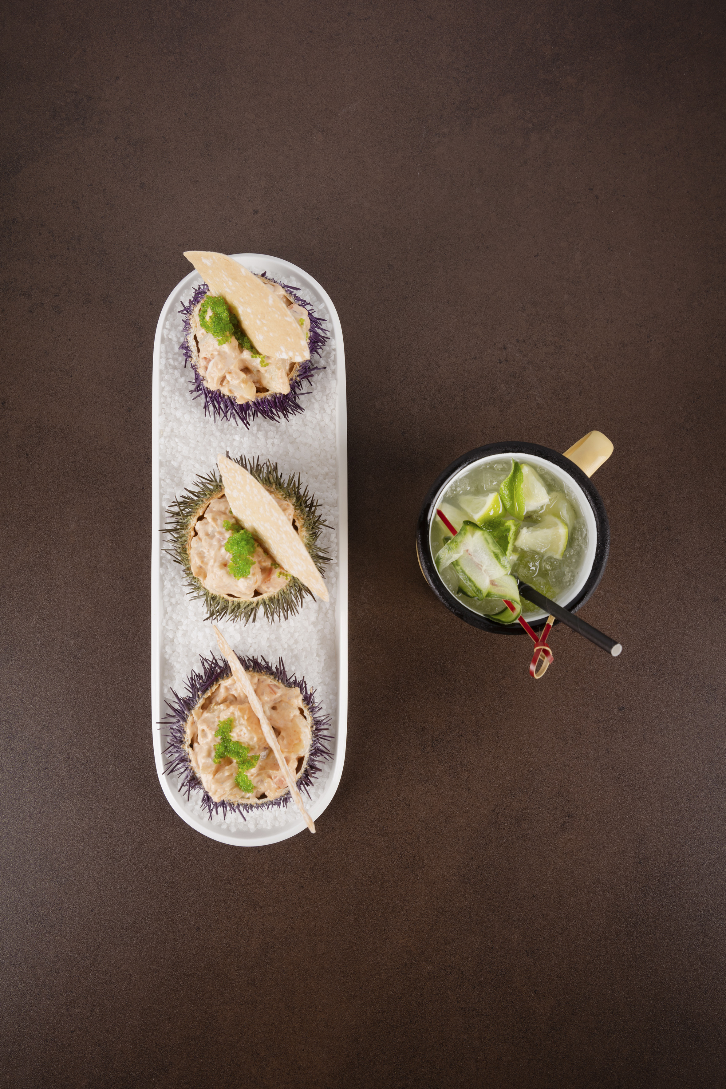 Sea urchin uni appetizer with green roe, crisps, and refreshing lime cocktail.