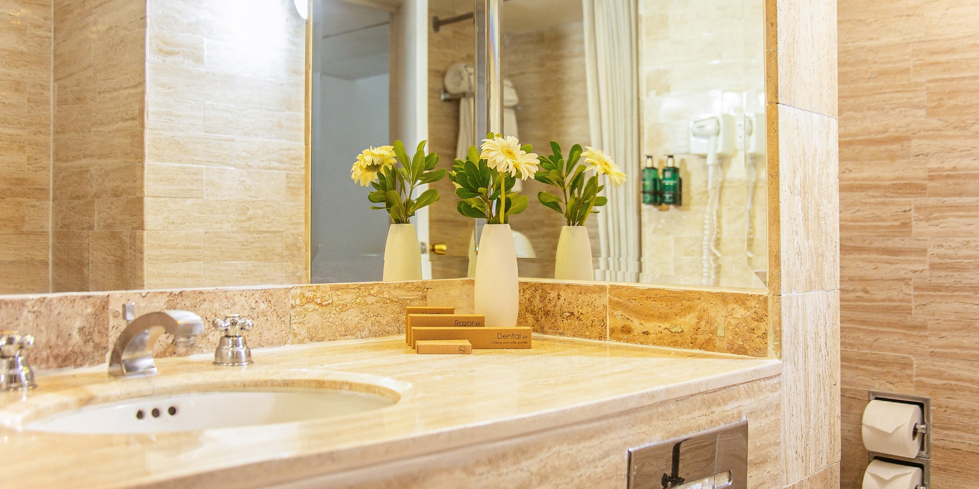 a bathroom sink with flowers in vases