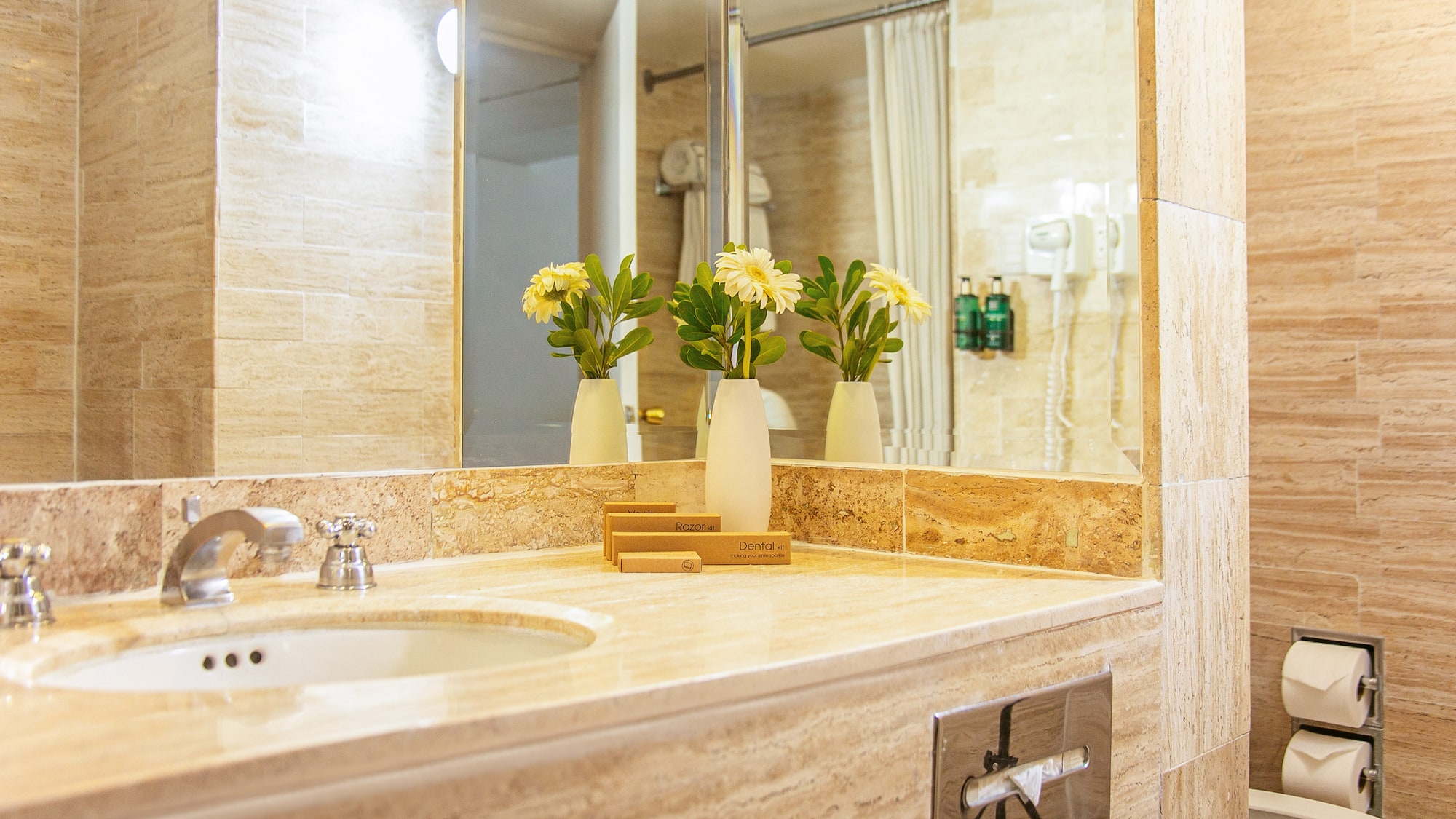 a bathroom sink with flowers in vases