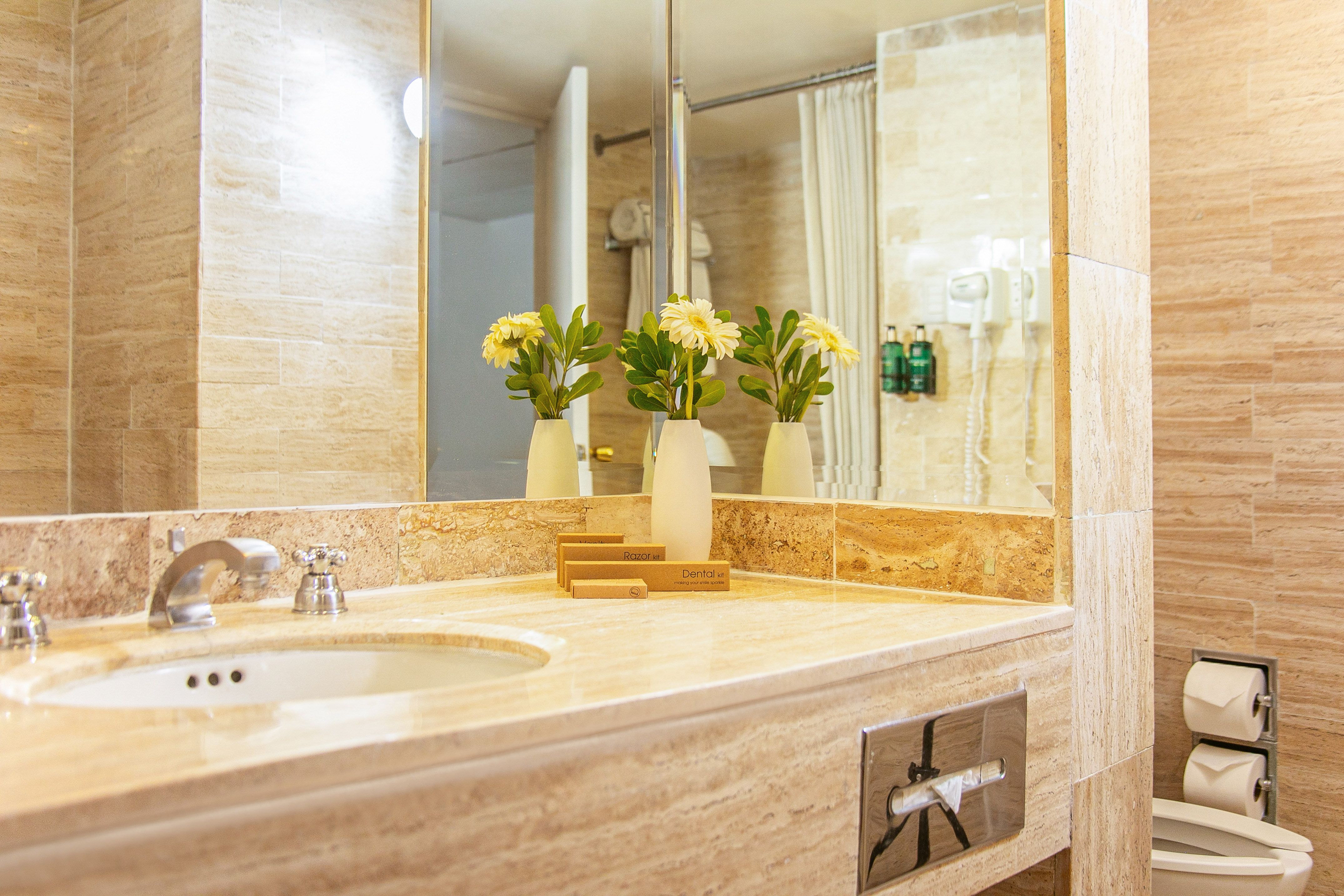 a bathroom sink with flowers in vases