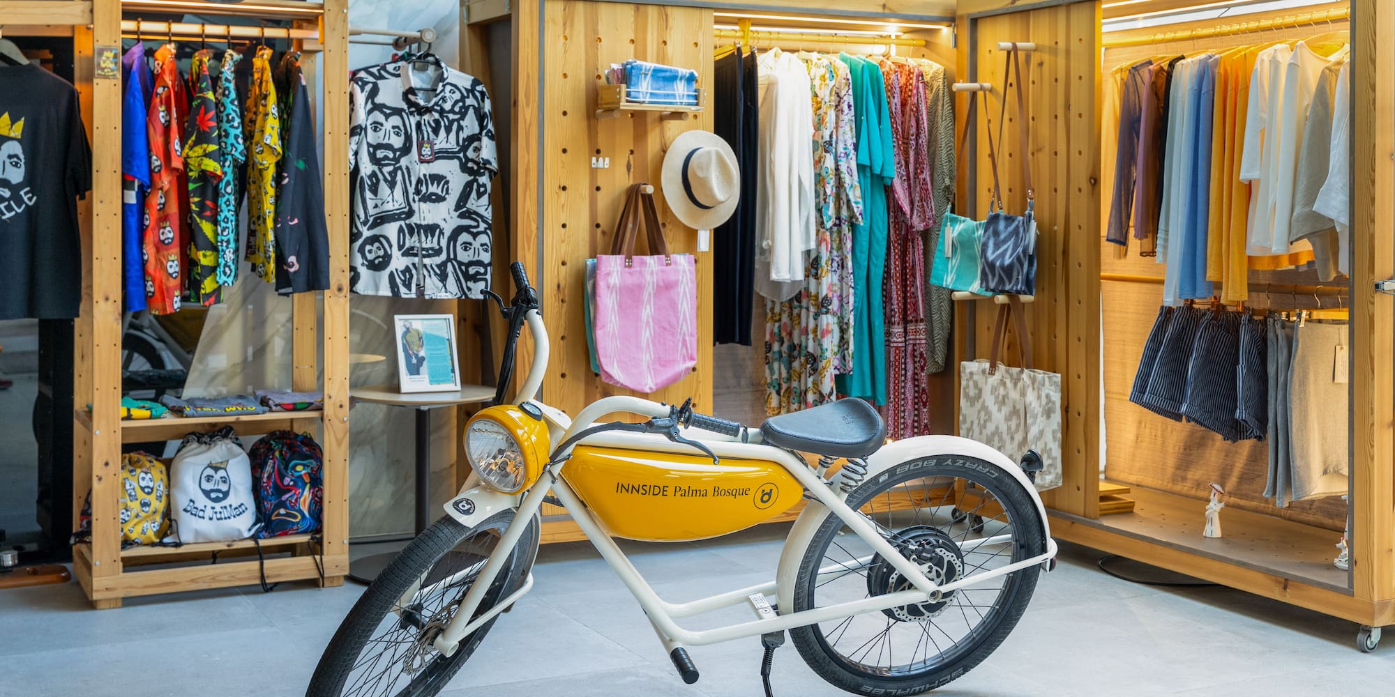 INNSIDE Palma Bosque e-bike in a colorful clothing boutique with resort wear.