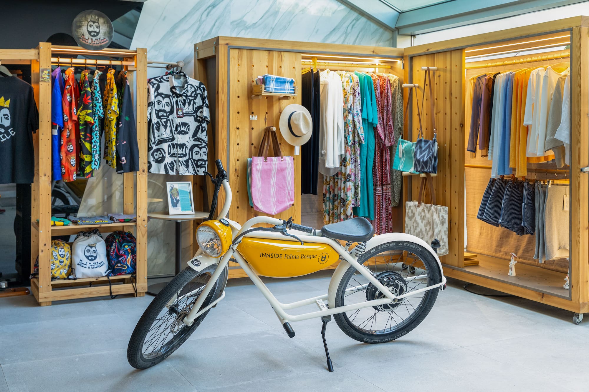INNSIDE Palma Bosque e-bike in a colorful clothing boutique with resort wear.