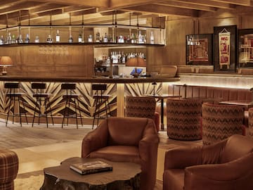 a room with a bar and chairs