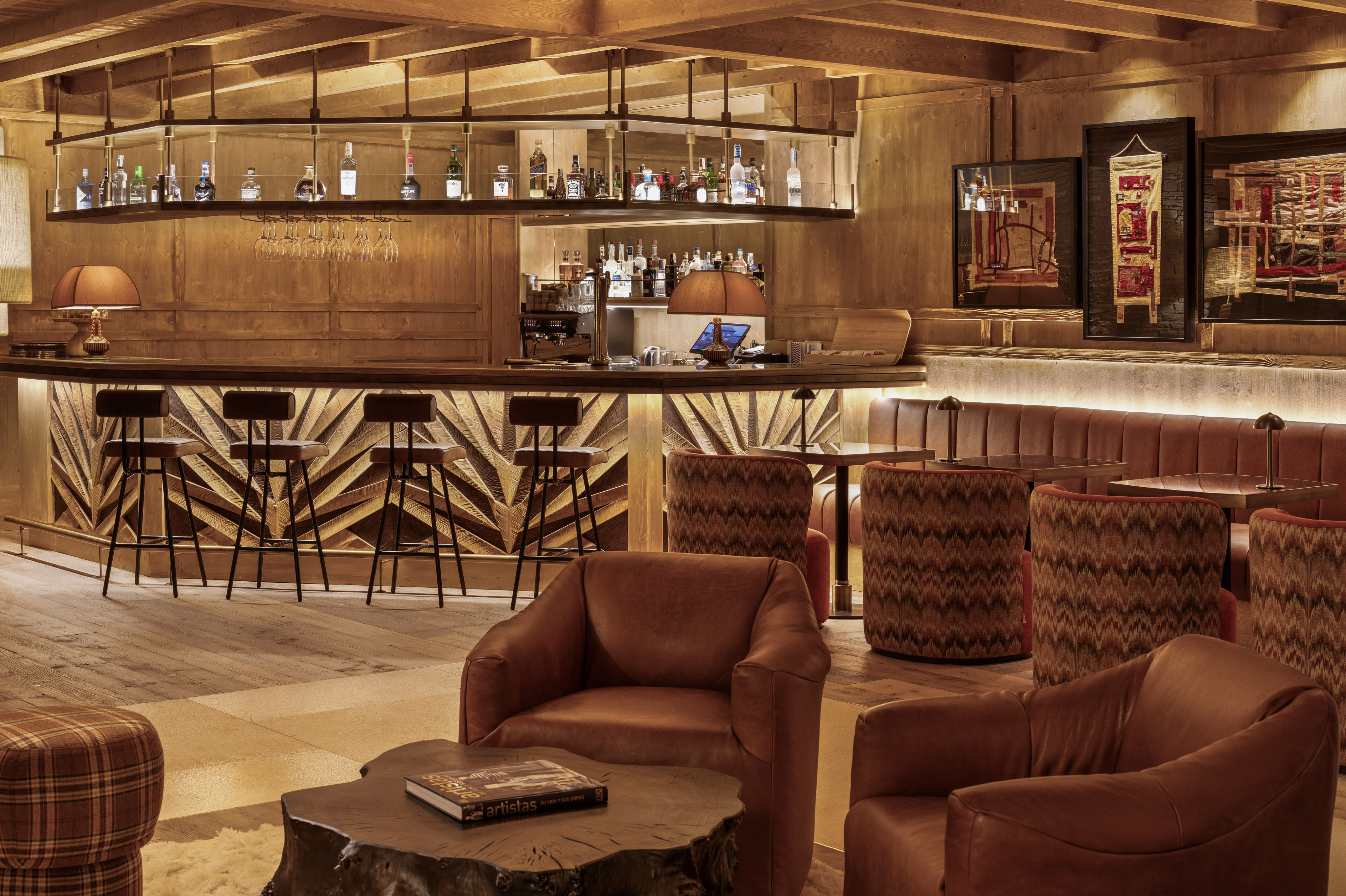 Cozy wooden bar lounge with leather armchairs, stylish bar, and warm lighting.