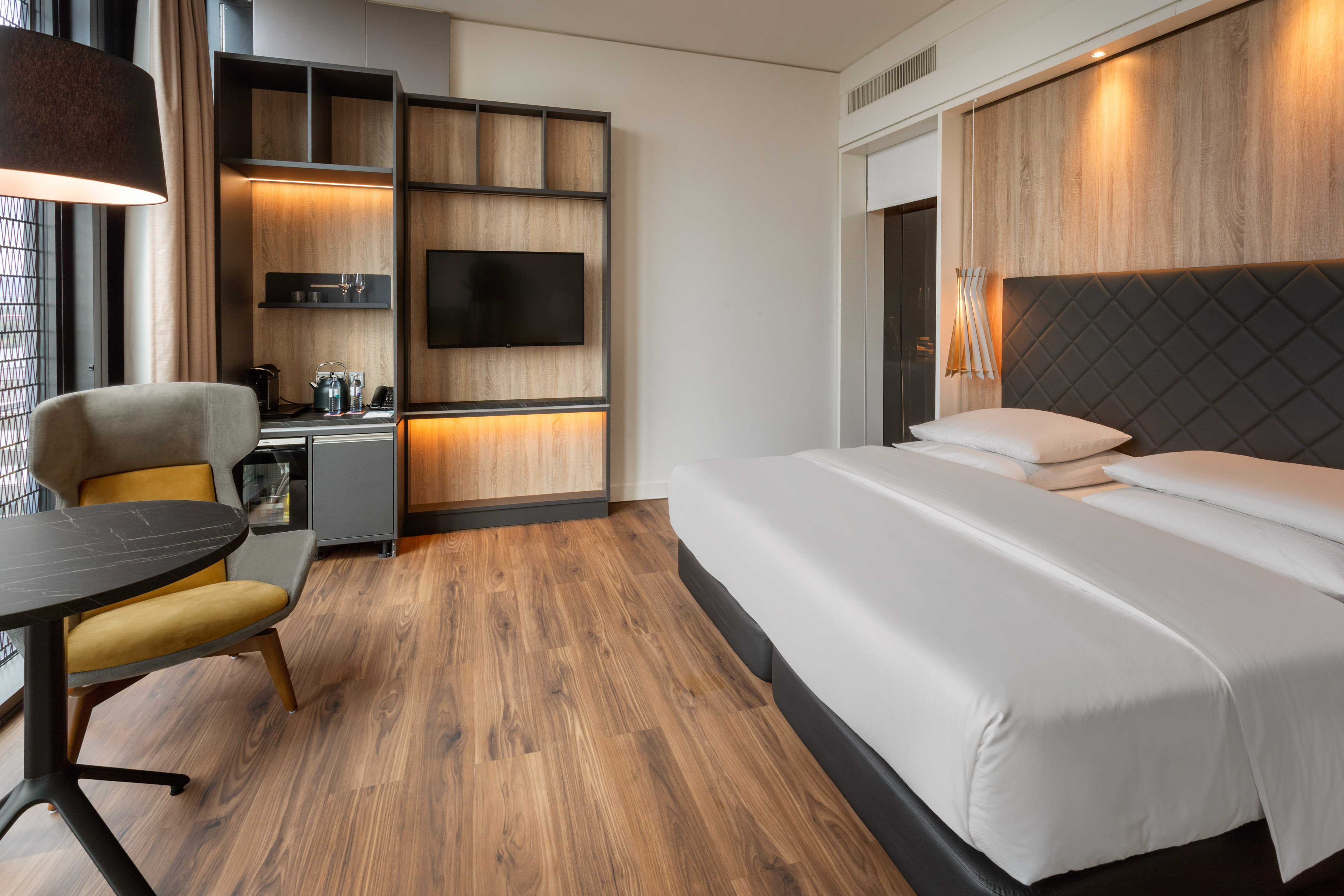 Stylish hotel room with comfortable bed, flat-screen TV, and mini-bar.