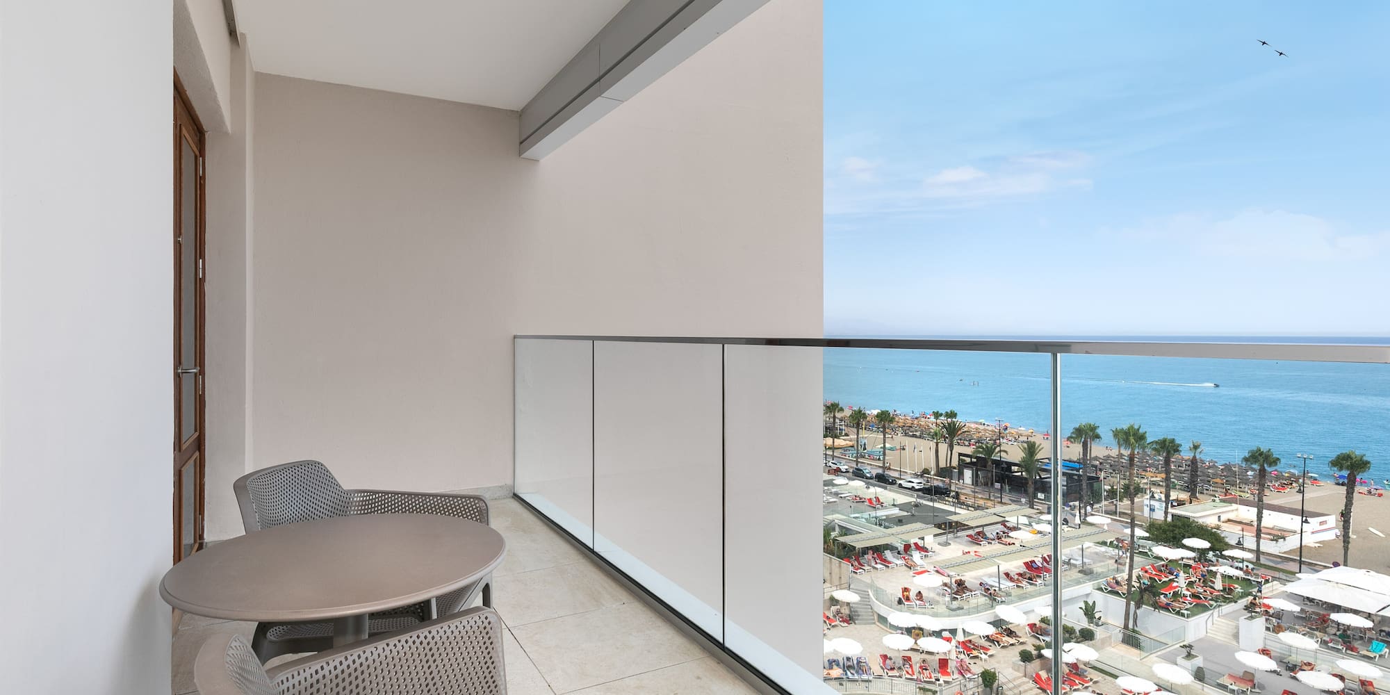 a balcony with chairs and a view of the beach