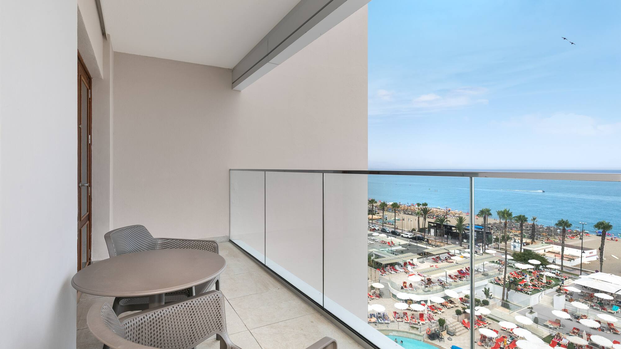 a balcony with chairs and a view of the beach