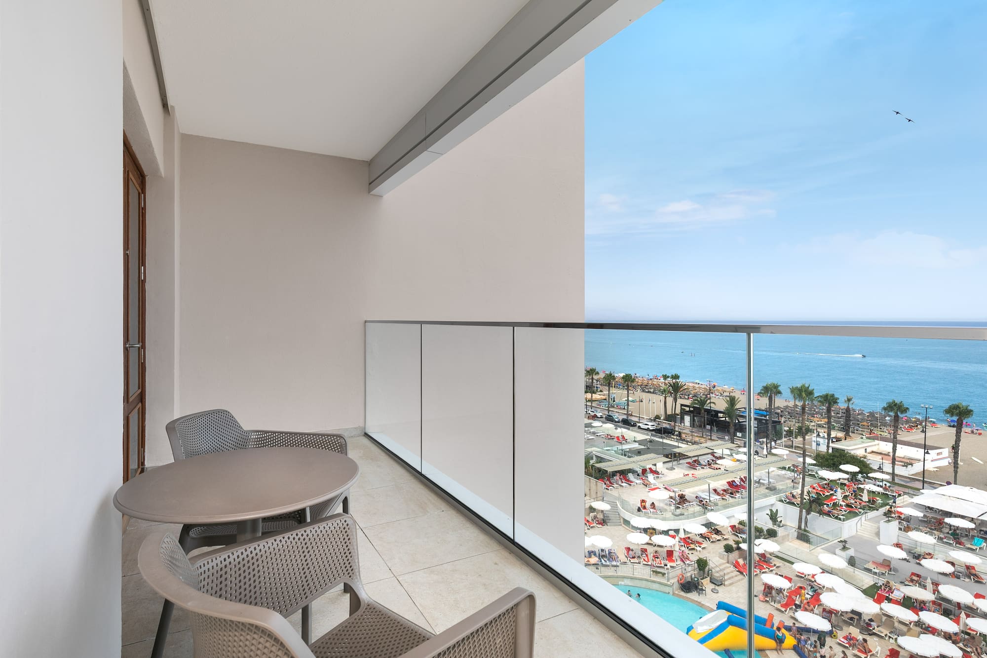 a balcony with chairs and a view of the beach