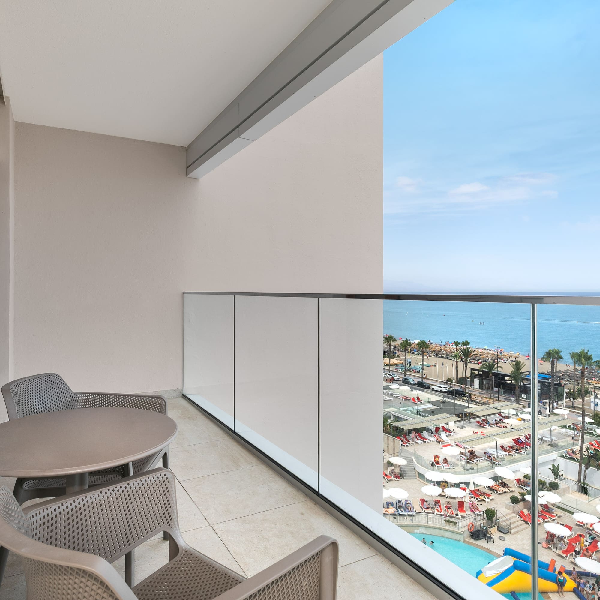 a balcony with chairs and a view of the beach