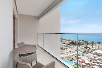 a balcony with chairs and a view of the beach