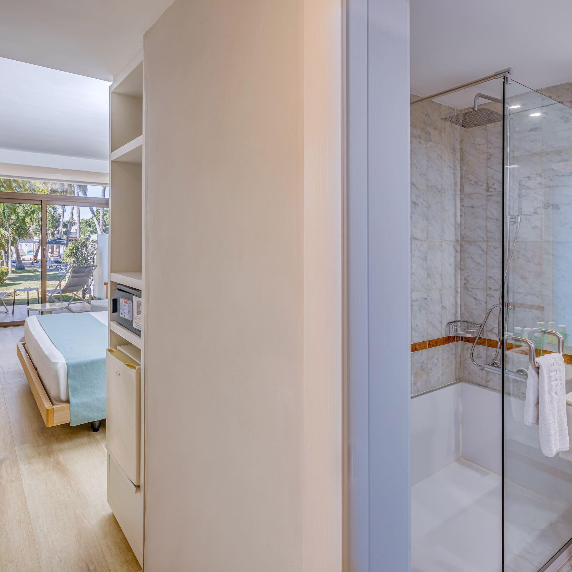 a bathroom with a glass shower and a bed