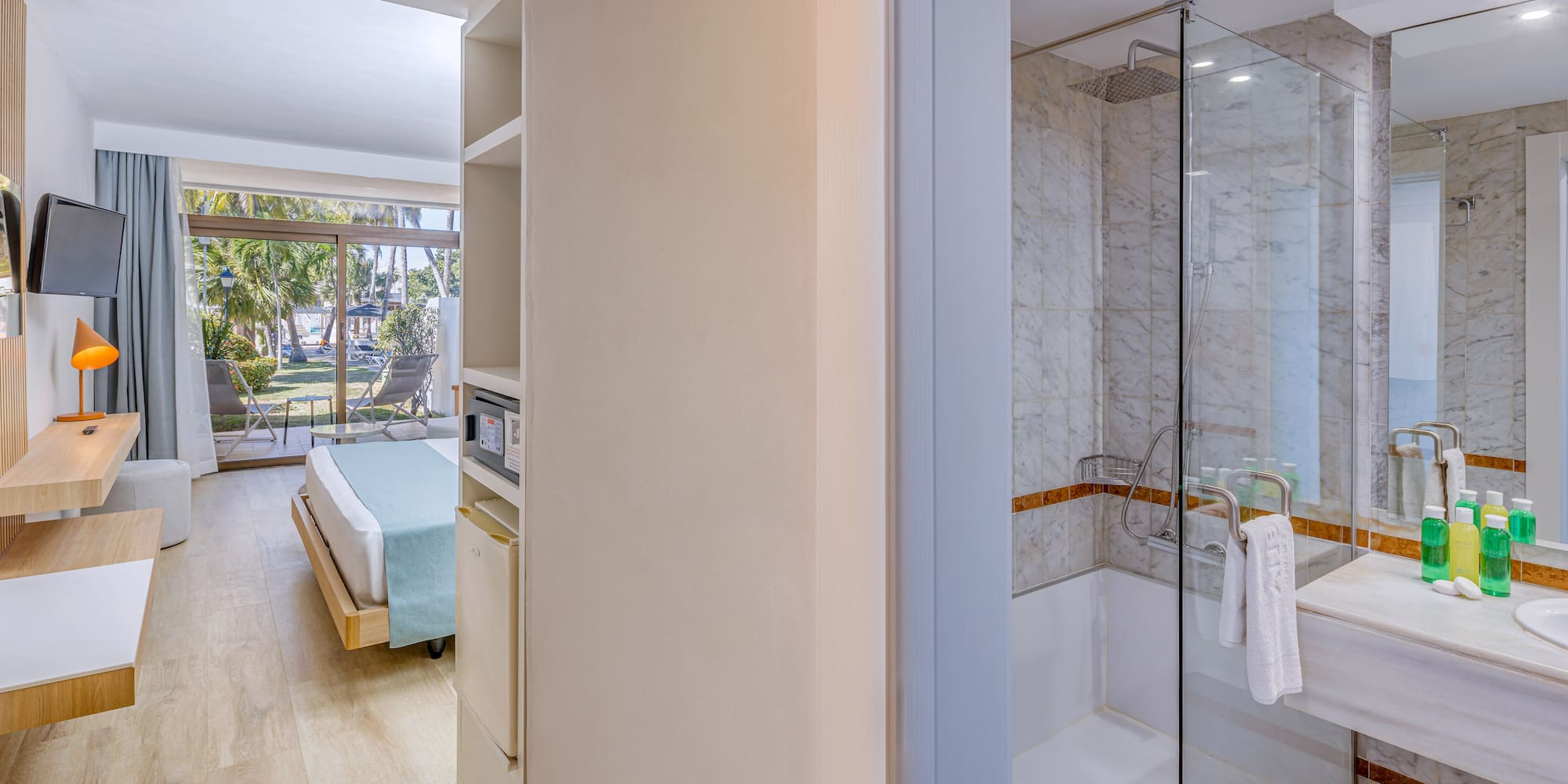 a bathroom with a glass shower and a bed