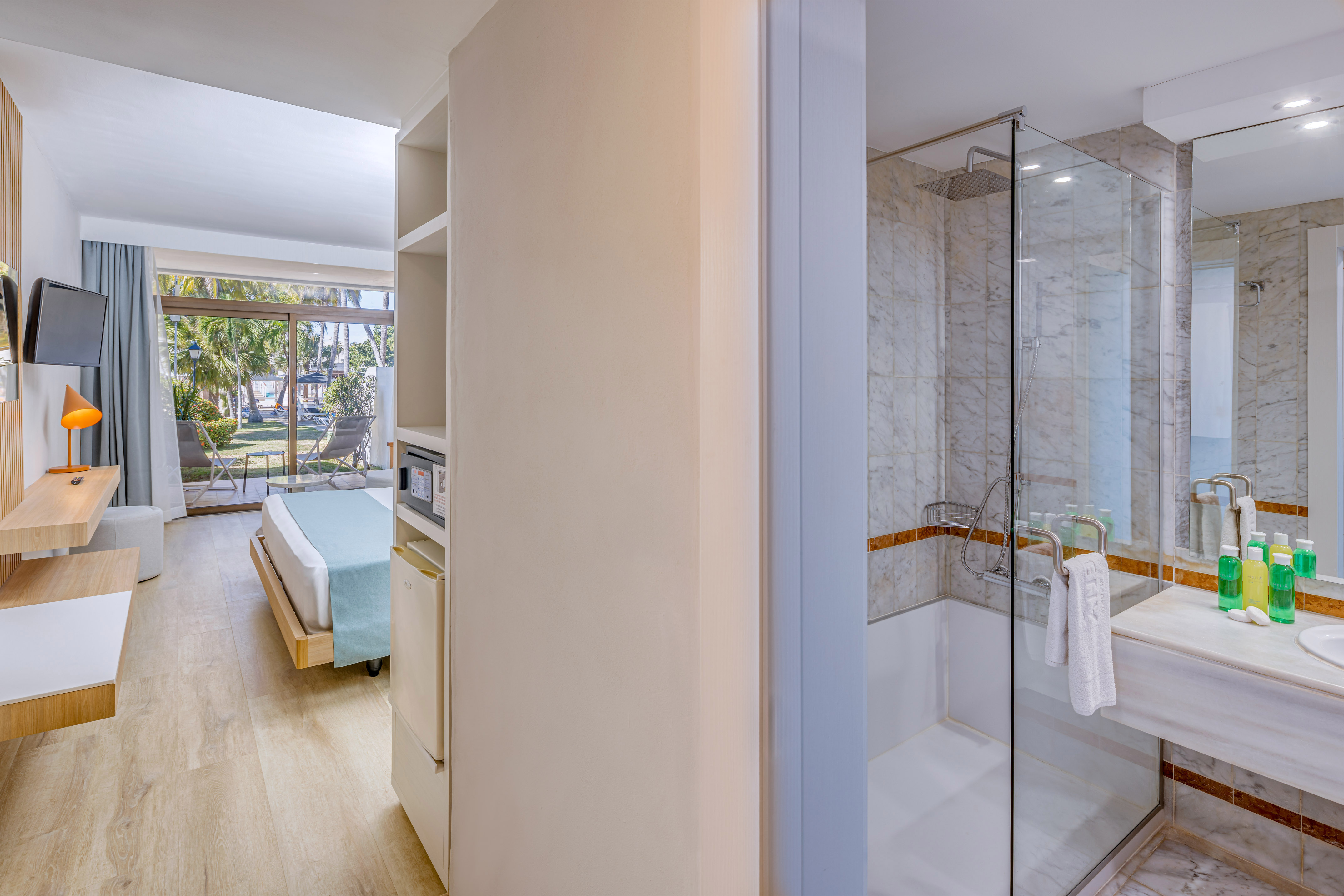 a bathroom with a glass shower and a bed