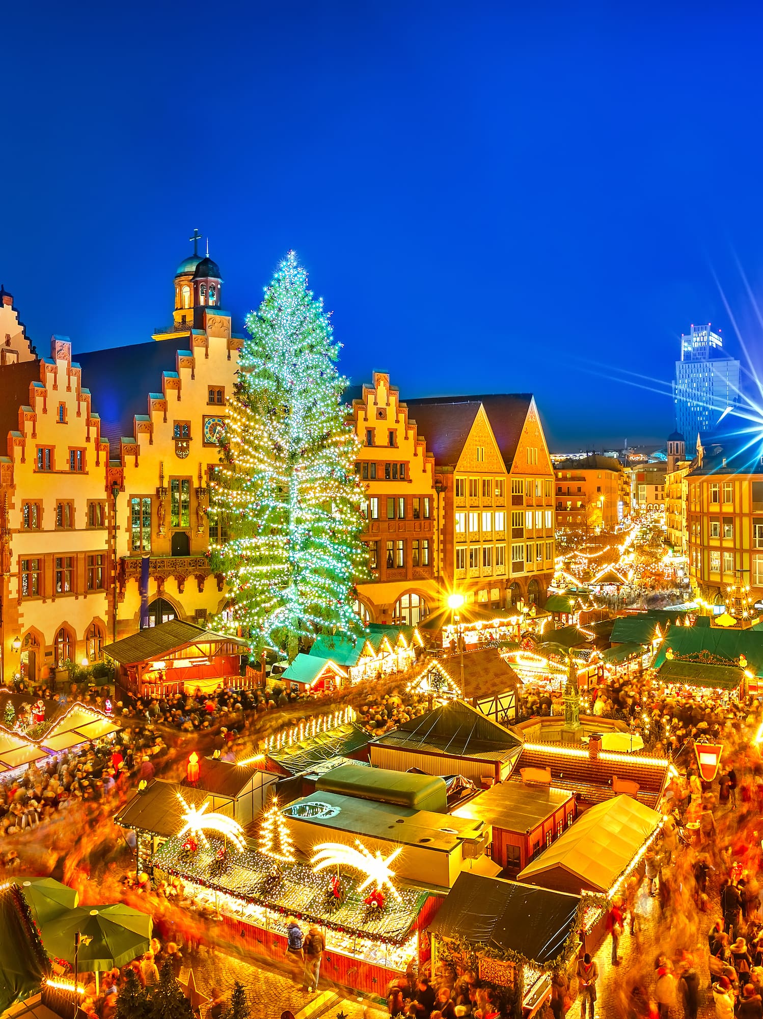 Frankfurt Christmas market at night, illuminated with festive stalls and tree.