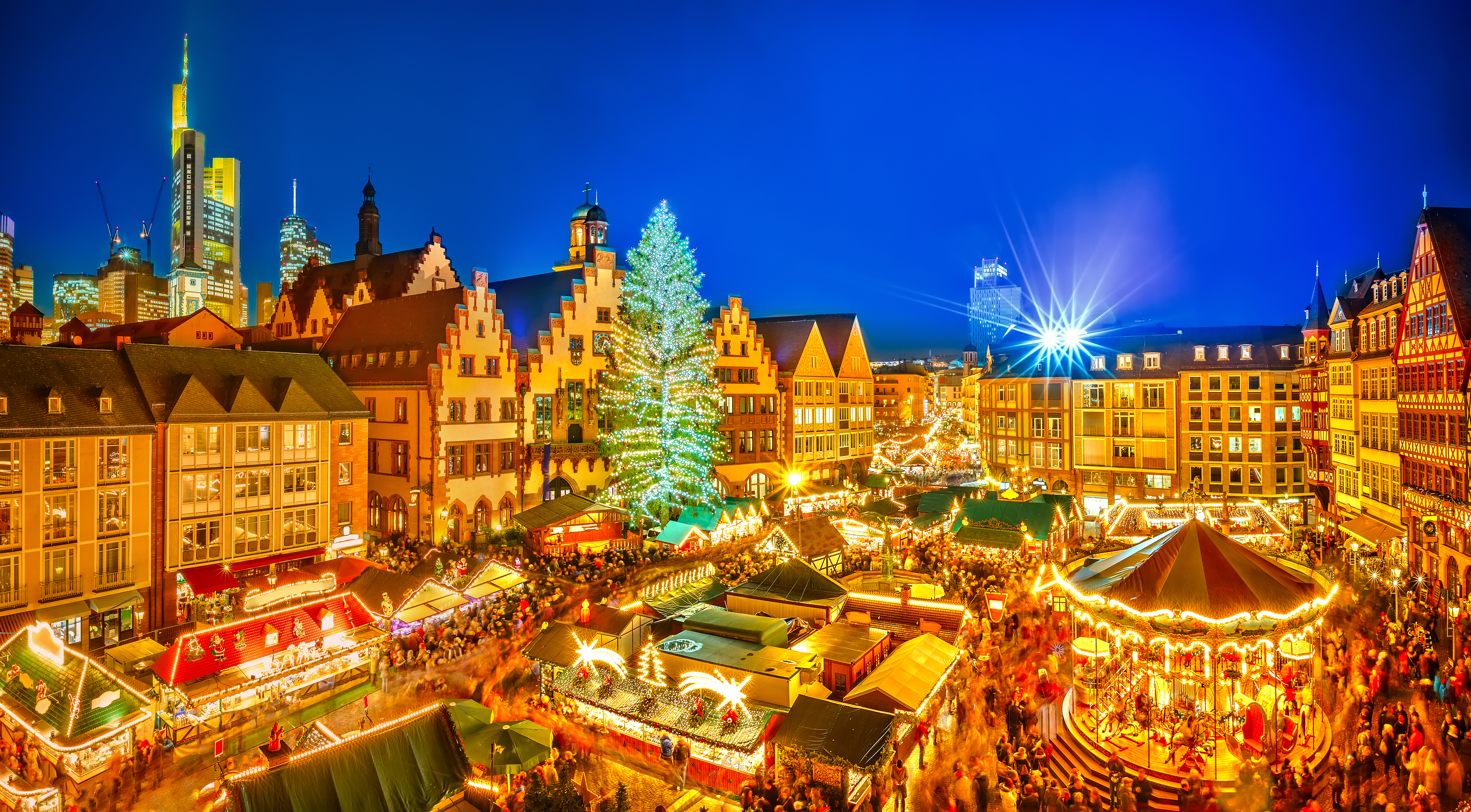 Frankfurt Christmas market at night, illuminated with festive stalls and tree.