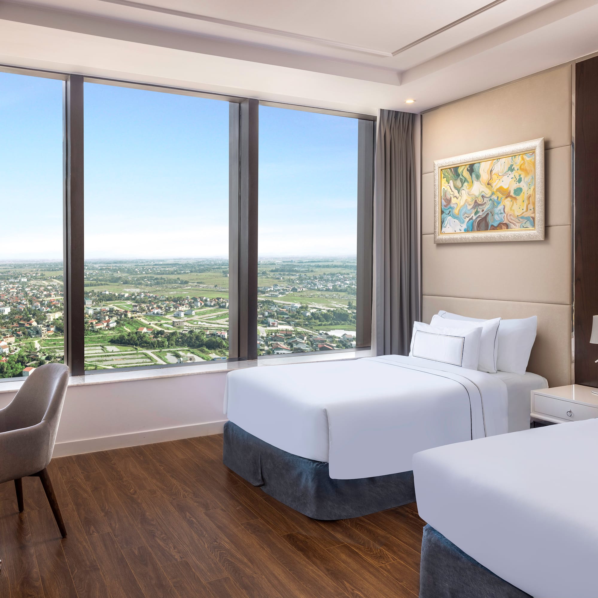 a room with two beds and a chair and a large window