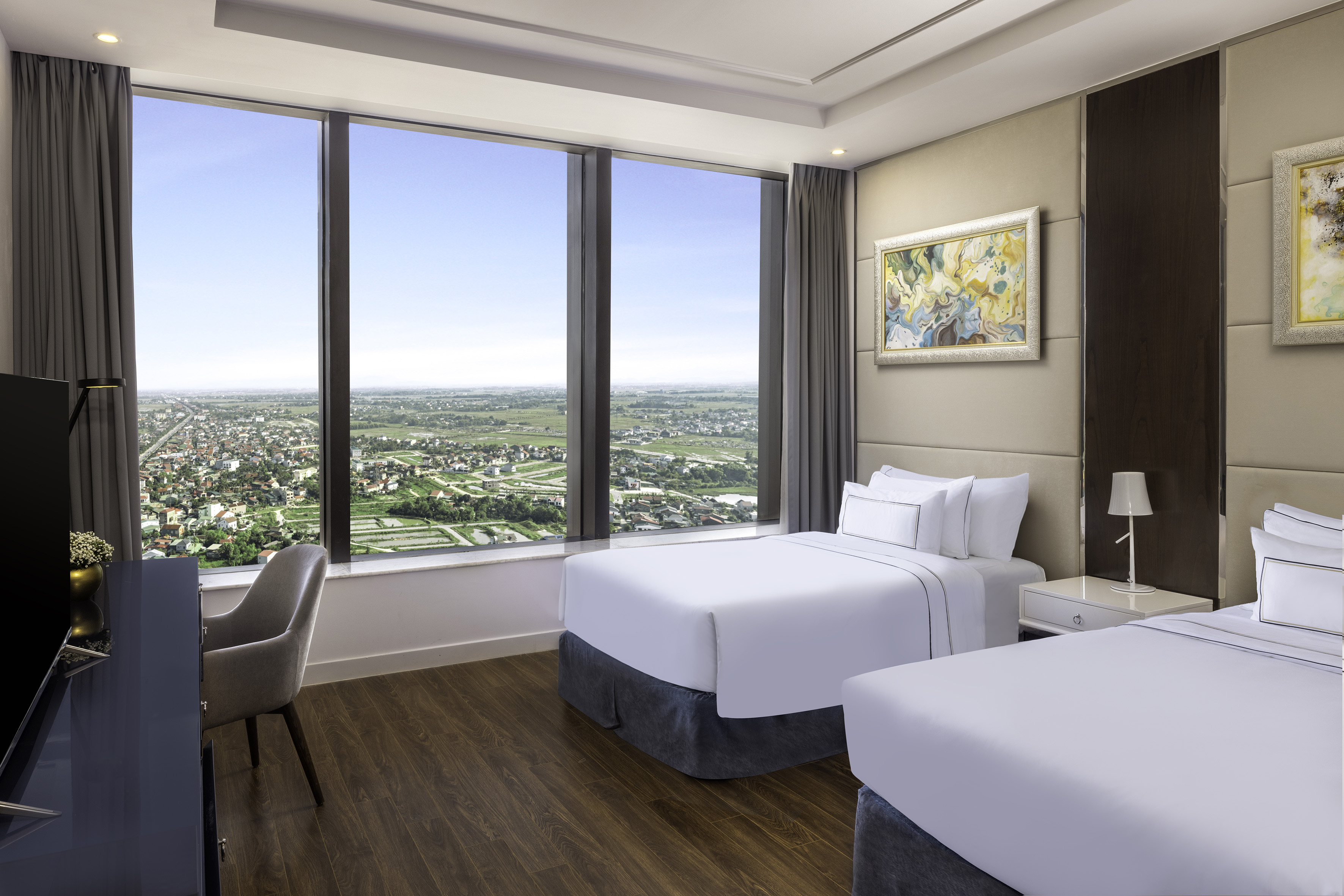 a room with two beds and a chair and a large window