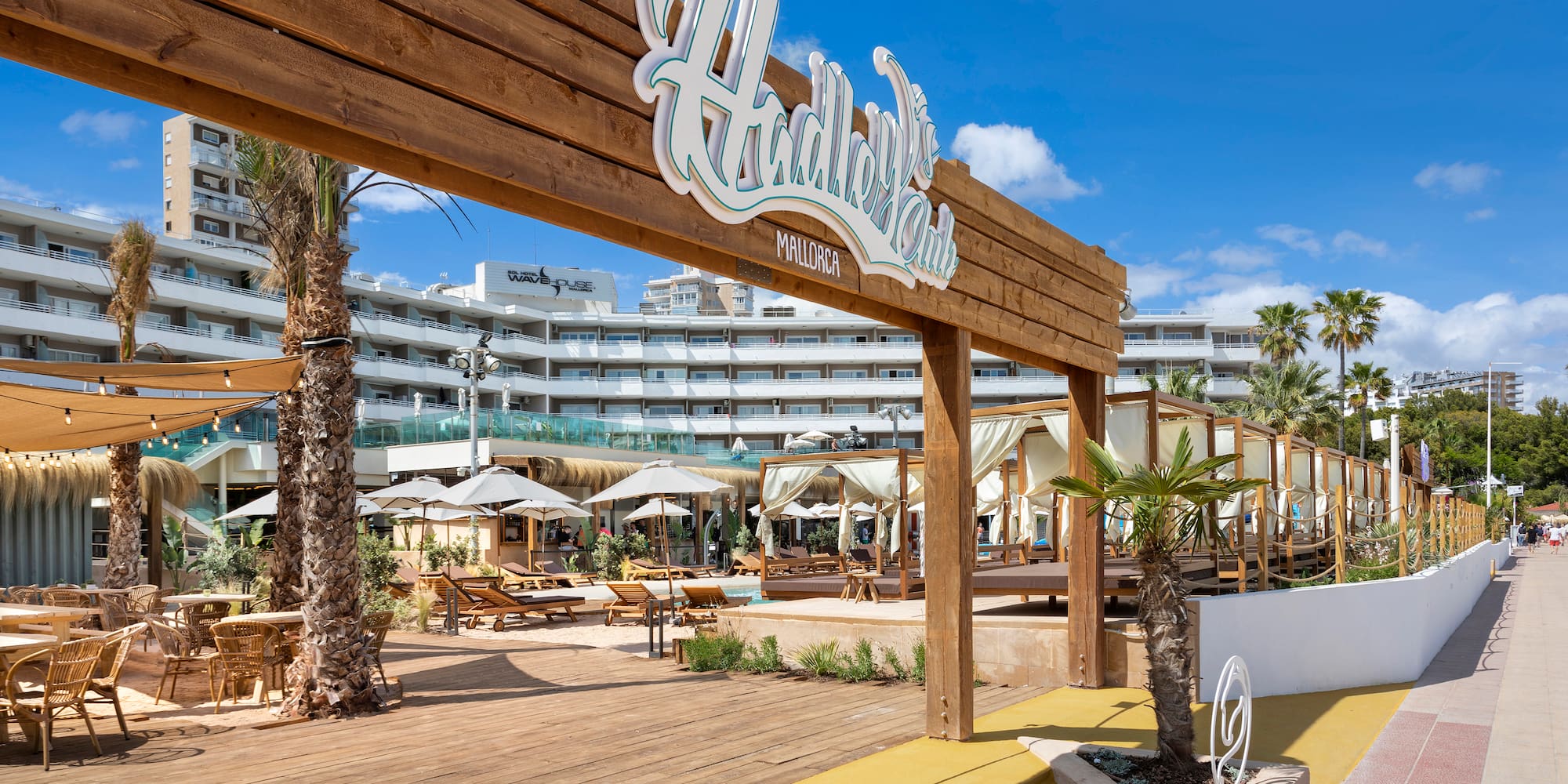 a wooden sign with palm trees and umbrellas